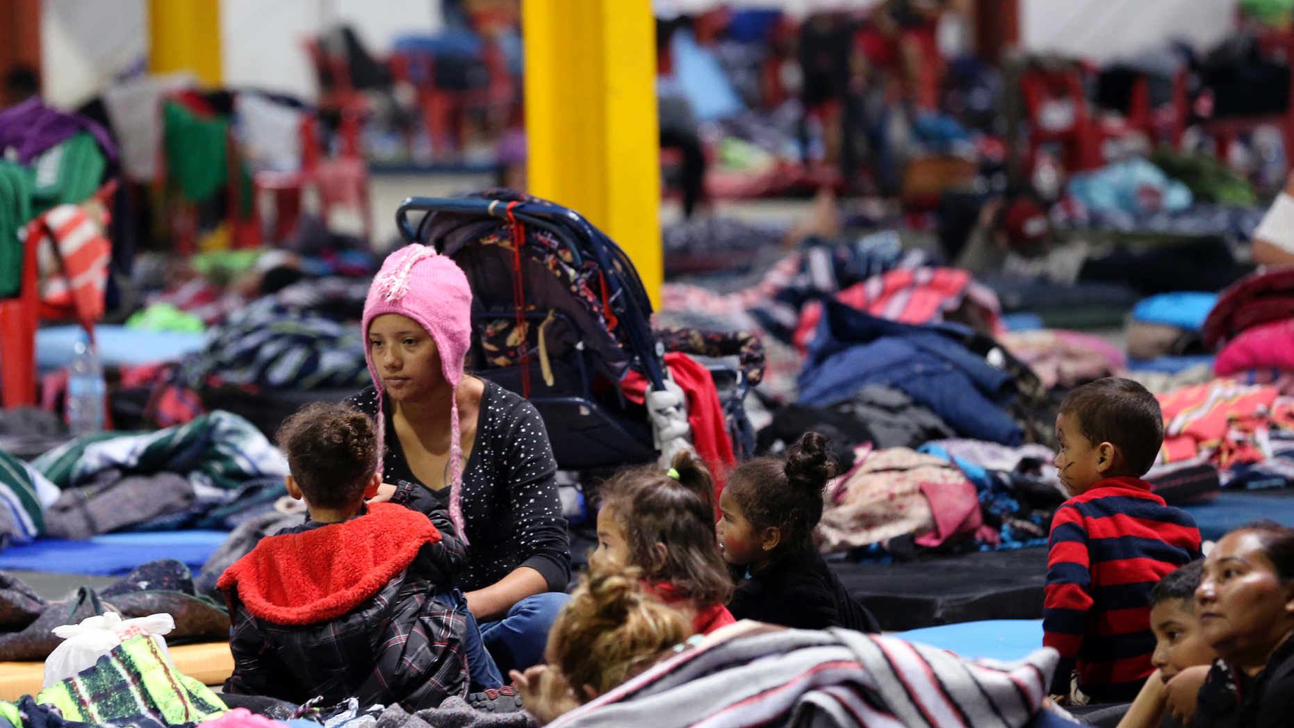 Honduran Delia Romero, 24, sits with her children in their sleeping area at a sheltered in Piedras Negras, Mexico, Tuesday, Feb. 5, 2019. A caravan of about 1,600 Central American migrants camped Tuesday in the Mexican border city of Piedras Negras, just west of Eagle Pass, Texas. The governor of the northern state of Coahuila described the migrants as "asylum seekers," suggesting all had express intentions of surrendering to U.S. authorities. (Jerry Lara/The San Antonio Express-News via AP)