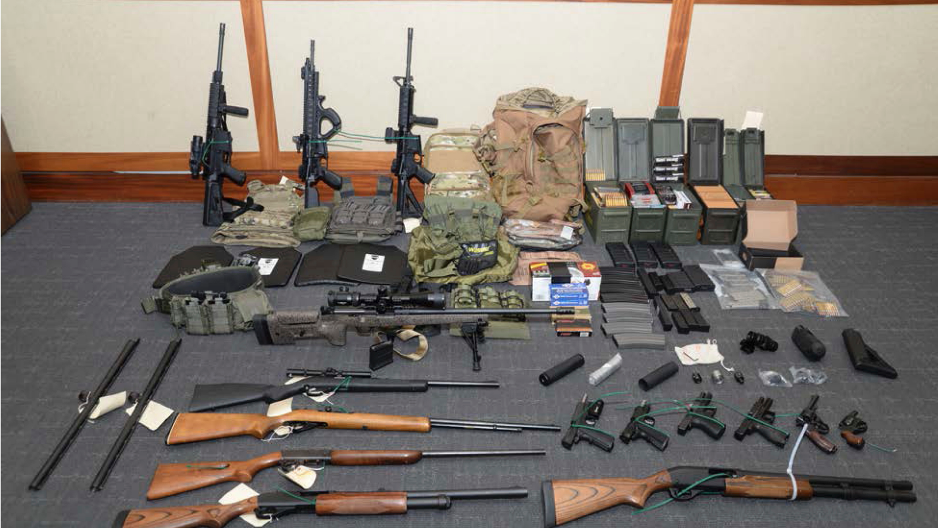 This image provided by the U.S. District Court in Maryland shows a photo of firearms and ammunition that was in the motion for detention pending trial in the case against Christopher Paul Hasson. Prosecutors say that Hasson, a Coast Guard lieutenant is a "domestic terrorist" who wrote about biological attacks and had a hit list that included prominent Democrats and media figures. He is due in court on Feb. 21 in Maryland. Prosecutors say Hasson espoused extremist views for years. Court papers say Hasson described an "interesting idea" in a 2017 draft email that included "biological attacks followed by attack on food supply." (U.S. District Court via AP)
