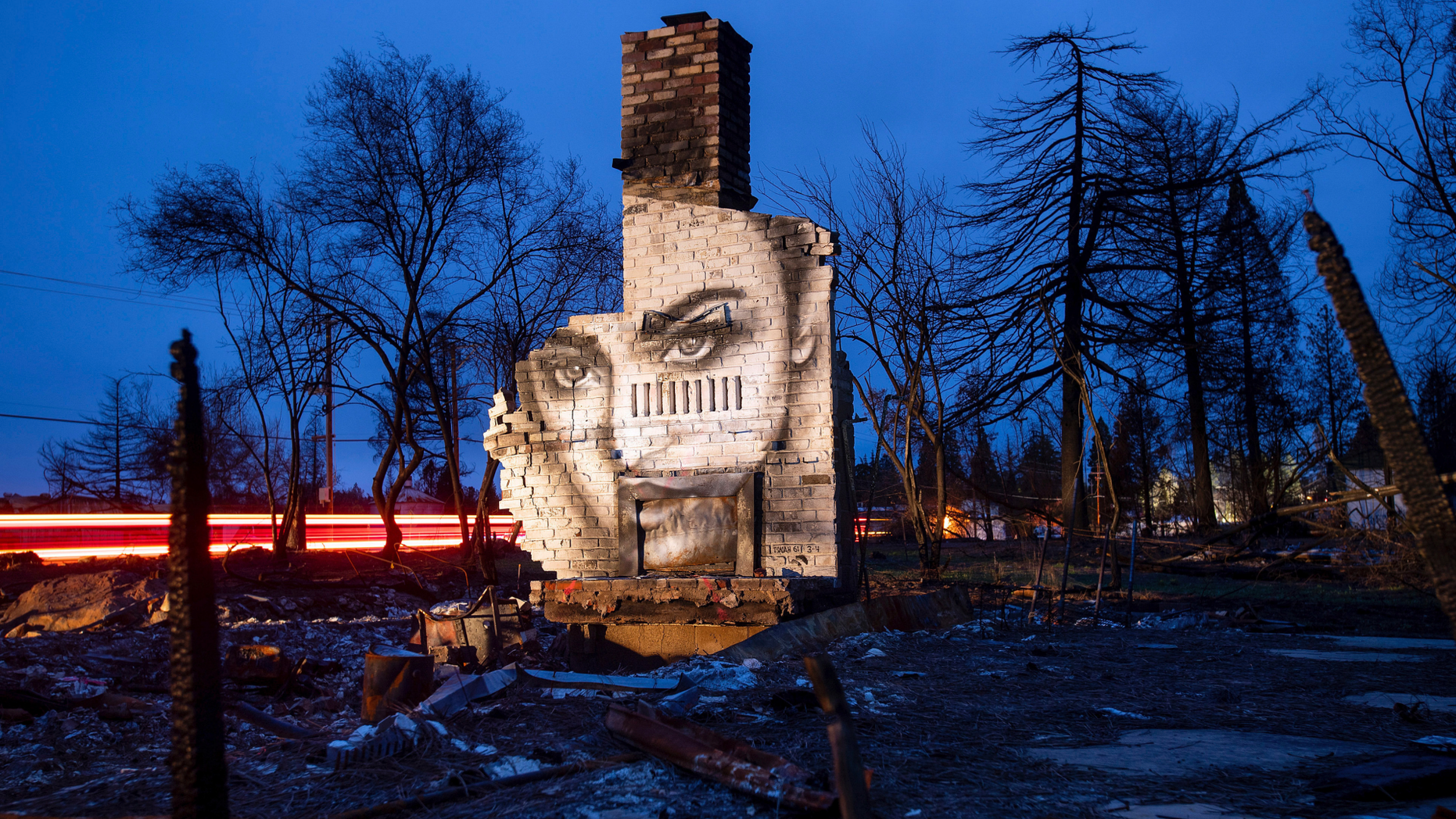 In this Feb. 8, 2019, photo, a mural by artist Shane Grammer adorns the chimney of a residence leveled by the Camp Fire in Paradise, Calif. Grammer says he painted murals throughout the fire-ravaged town to convey hope in the midst of destruction. In the 100 days since a wildfire nearly burned the town of Paradise off the map, the long recovery is just starting. Work crews have been cutting down trees and clearing burned-out lots, but Paradise is mostly a ghost town where survivors still dig for keepsakes in the foundations of their homes. (AP Photo/Noah Berger)