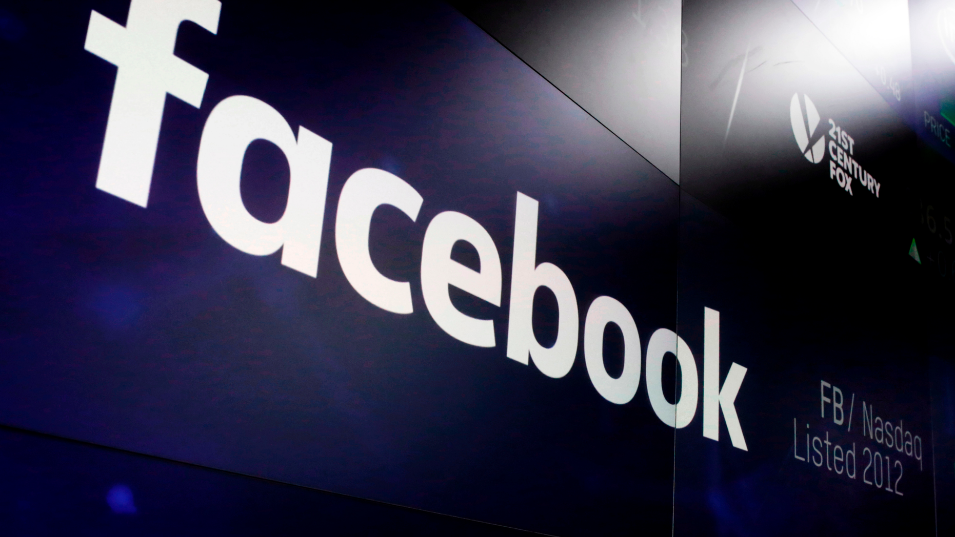 FILE- In this March 29, 2018, file photo, the logo for Facebook appears on screens at the Nasdaq MarketSite in New York's Times Square. (AP Photo/Richard Drew, File)