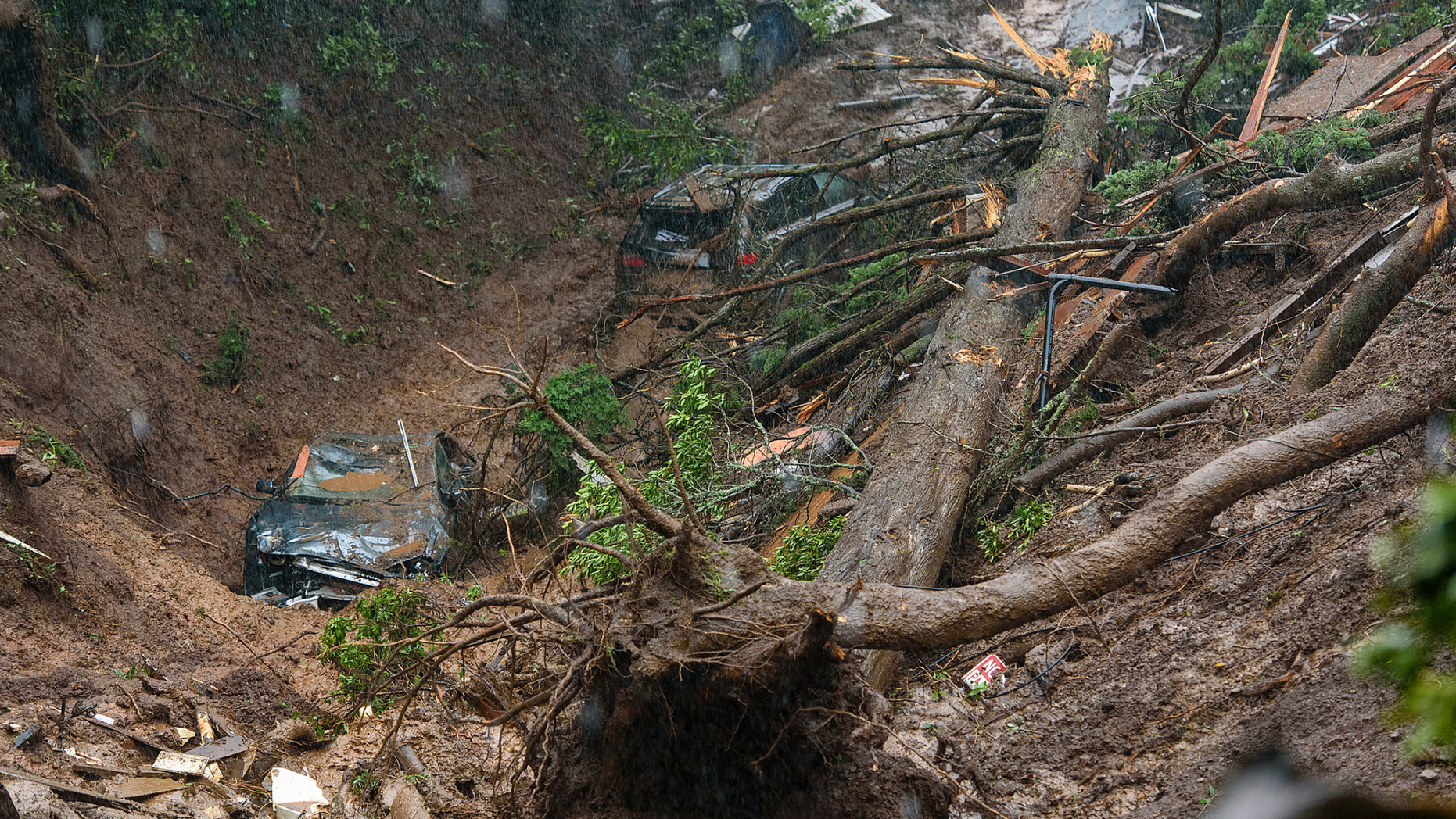 Cars and a large tree are seen in a debris trail in the aftermath of a mudslide that destroyed three homes on a hillside in Sausalito, Calif., Thursday, Feb. 14, 2019. The National Weather Service says the atmospheric river sagged southward from Northern California overnight and is pointed at the southwestern corner of the state early Thursday. (AP Photo/Michael Short)