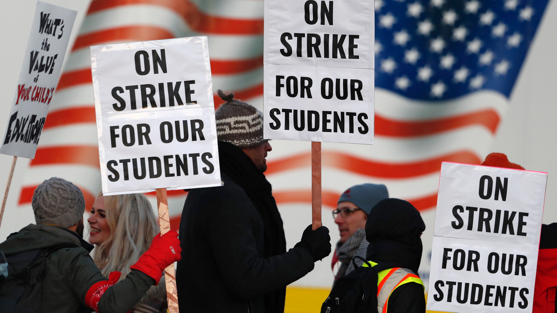 FILE - In this Feb. 11, 2019, file photo, teachers carry placards as they walk a picket line outside South High School in Denver. Oakland teachers say they will strike starting Thursday, Feb. 21. The union representing the 3,000 teachers announced the walkout Saturday, Feb. 16, making it the latest in a wave of educator activism that has swept the U.S. since last spring. (AP Photo/David Zalubowski, File)
