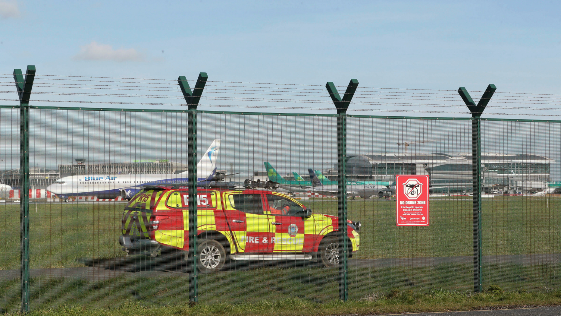 An emergency service vehicle by the perimeter fence after a confirmed drone sighting forced the temporary suspension of operations at Dublin Airport, Ireland, Thursday Feb. 21, 2019. Flights at Dublin Airport were grounded for a short time Thursday, to ensure the safety and security of passengers after a confirmed drone sighting. (Nial Carson/PA via AP)