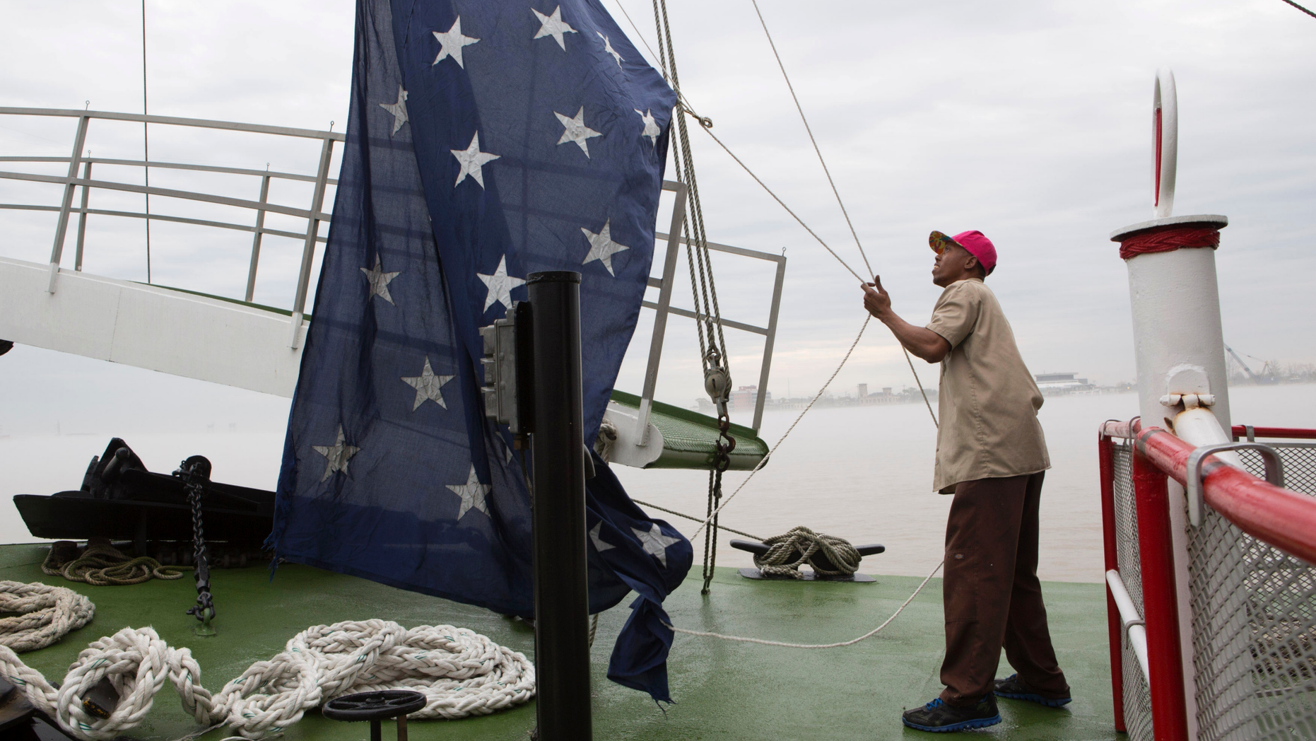 FILE - In this March 15, 2015 file photo, Dwayne McCornick, a deck hand on the Natchez steamboat for 16 years, raises the Union Jack naval flag on the Mississippi River in New Orleans. After nearly 17 years, United States Navy warships will return to flying the Union Jack, replacing the First Navy Jack flown in the wake of the Sept. 11 attacks.
News outlets report Chief of Naval Operations Adm. John Richardson issued an order Thursday, Feb. 21, 2019, calling for the blue banner with 50 white stars to return June 4 to commemorate World War II’s Battle of Midway. The Navy’s current maritime flag, the First Navy Jack, featured red and white stripes with a rattlesnake and the words “Don’t Tread On Me.” (AP Photo/Samantha Kaplan, File)