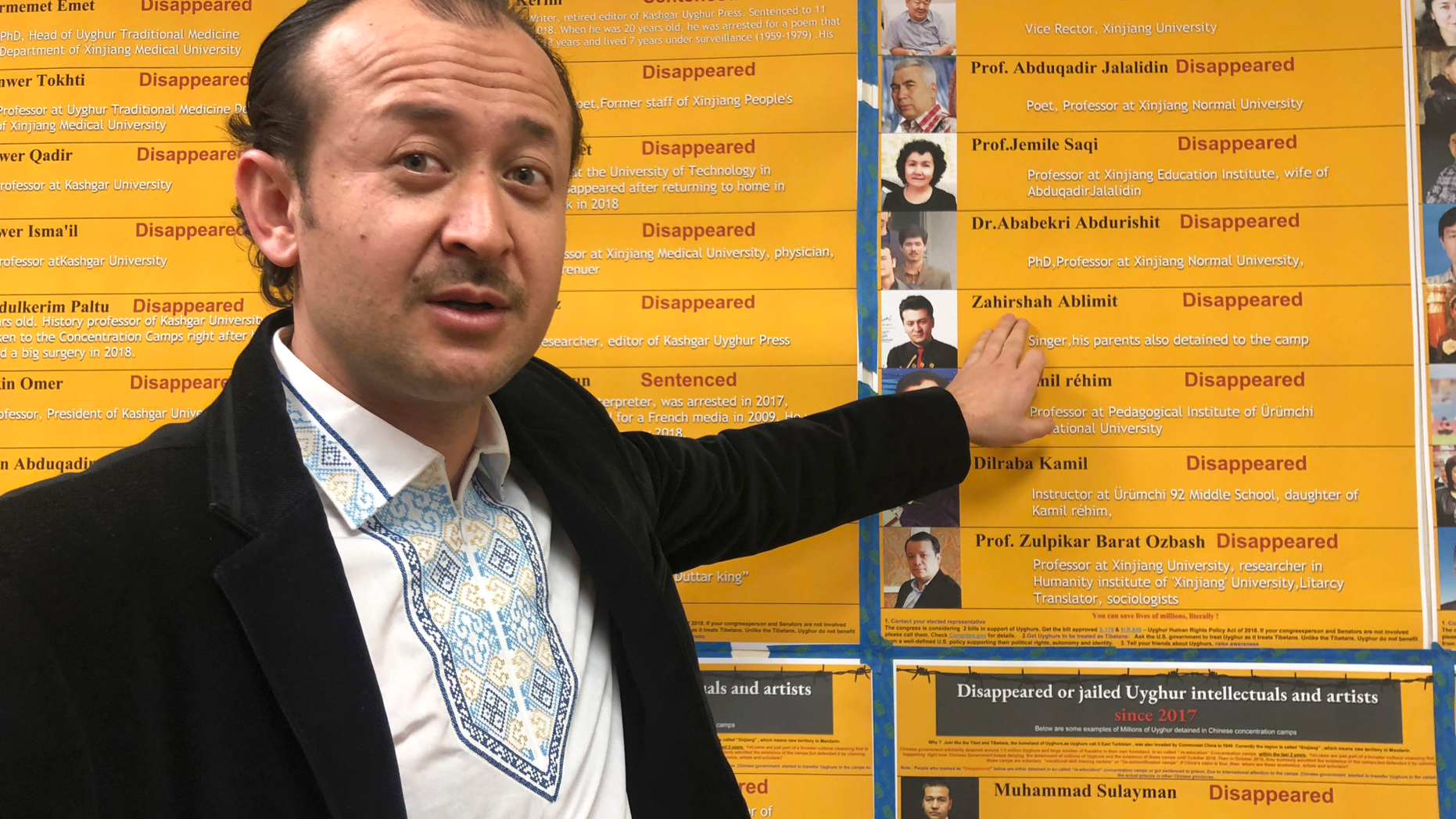 Abudwaris Ablimit points to a photo of his brother during a gathering to raise awareness about loved ones who have disappeared in China's far west, in Washington DC on Sunday, Feb. 24, 2019. The western region of Xinjiang has been subject to a severe security crackdown in recent years that has made surveillance cameras and police checkpoints ubiquitous. The dragnet has made surveillance cameras and police checkpoints ubiquitous, and placed an estimated 1 million Uighurs and others in extrajudicial internment camps. (AP Photo/Christina Larson)