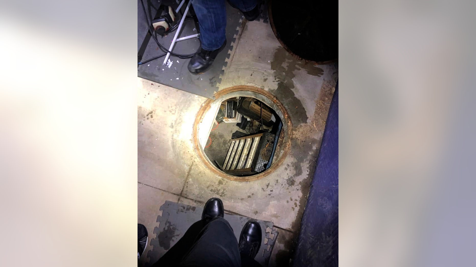 This Thursday, Feb. 7, 2019, photo released by the City of Fontana Police Department shows a manhole leading to an underground shooting range police found while searching the Southern California home of an alleged motorcycle gang in Fontana, Calif. The Fontana Police Department said on Facebook that officers discovered numerous weapons and thousands of rounds of ammunition that were seized during the search Thursday night. (City of Fontana Police Department via AP)