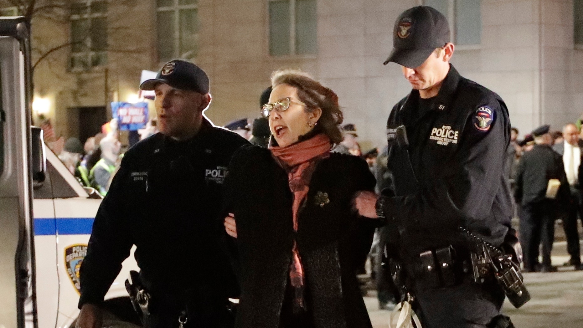 A protester is taken into custody outside Trump International Hotel &amp; Tower on Friday, Feb. 15, 2019, in New York. Some people have been arrested while protesting President Donald Trump's national emergency declaration. The NYPD wasn't immediately able to say how many people were taken into custody outside the hotel. (AP Photo/Frank Franklin II)