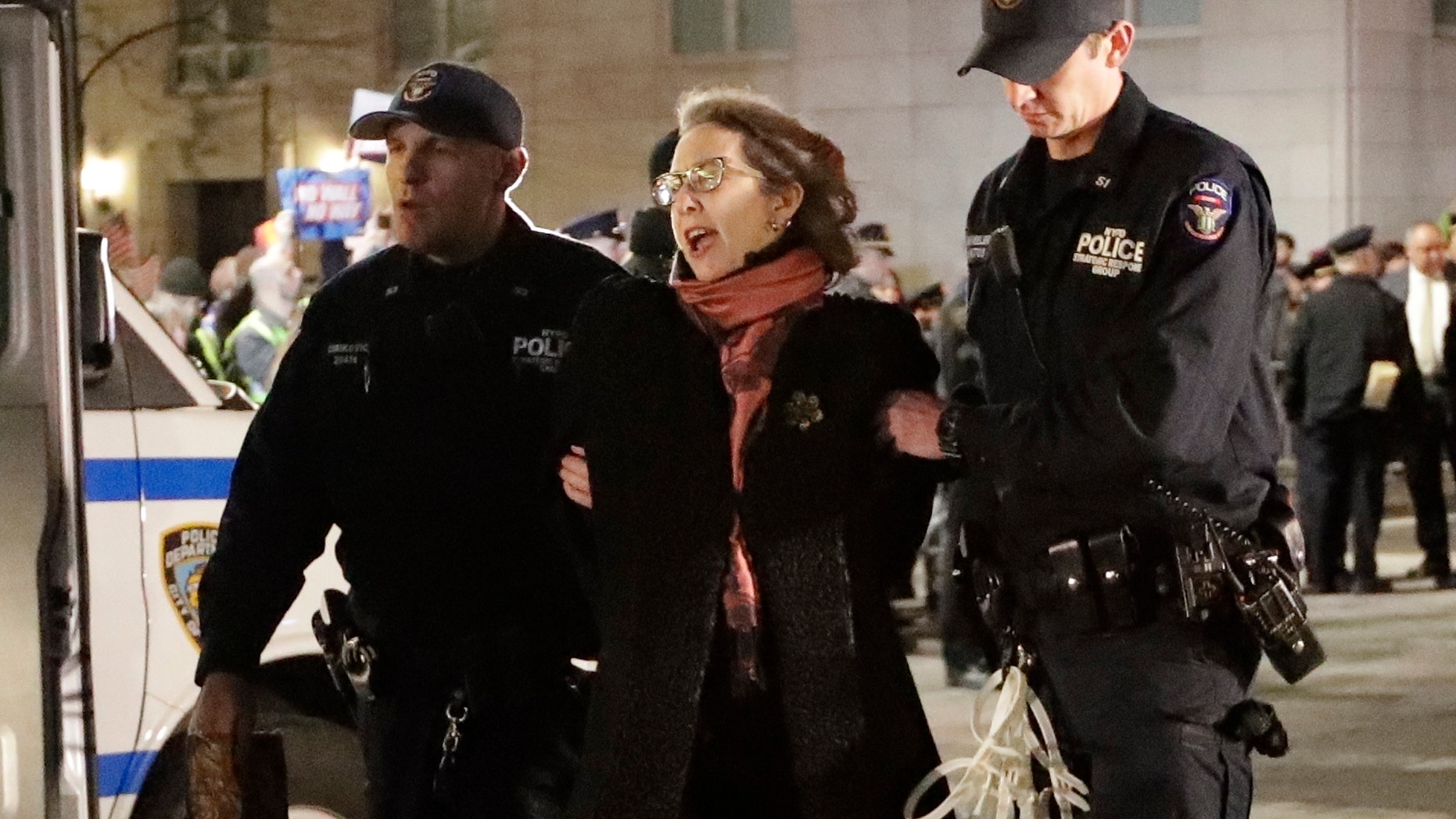 A protester is taken into custody outside Trump International Hotel & Tower on Friday, Feb. 15, 2019, in New York. Some people have been arrested while protesting President Donald Trump's national emergency declaration. The NYPD wasn't immediately able to say how many people were taken into custody outside the hotel. (AP Photo/Frank Franklin II)
