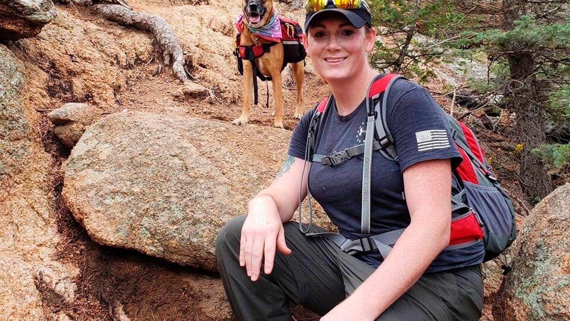This undated photo provided by her wife Jessica Kibodeaux shows Lindsey Muller and her dog Emma hiking in the Cheyenne Mountains west of Fort Carson, Colo. Muller, a 19-year combat veteran who served multiple tours in Iraq, diligently followed the Pentagon guidelines to transition. In the nearly three years since the U.S. military welcomed transgender people into the armed forces in 2016, they have served without incident. Some, like Muller, have earned prestigious medals or received other forms of recognition. (Jessica Kibodeaux via AP)