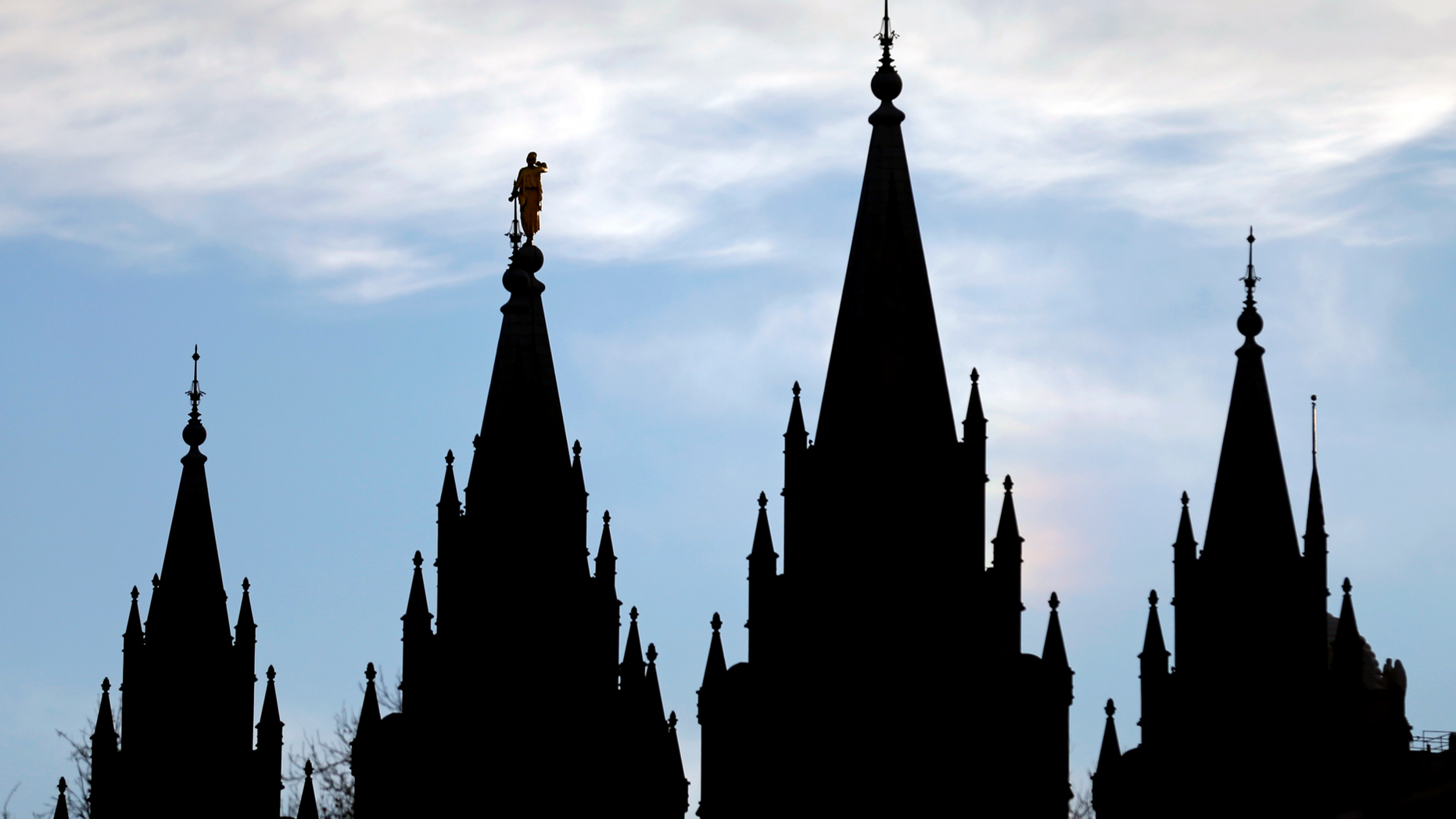 FILE- In this Jan. 3, 2018, file photo, the angel Moroni statue, silhouetted against the sky, sits atop the Salt Lake Temple at Temple Square in Salt Lake City. The Mormon church won't stand in the way of a proposal to ban gay conversion therapy for minors in its home base of Utah, a position that advocates heralded as a milestone in the conservative state. (AP Photo/Rick Bowmer, File)