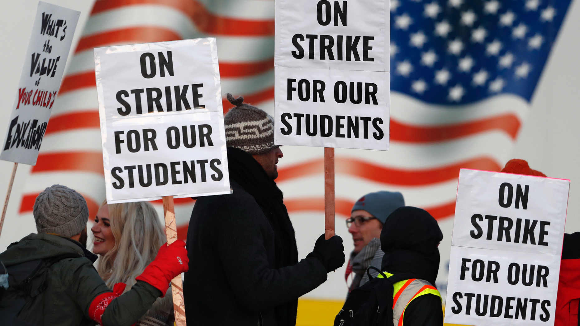 Teachers carry placards as they walk a picket line outside South High School early Monday, Feb. 11, 2019, in Denver. The strike on Monday is the first for teachers in Colorado in 25 years after failed negotiations with the school district over base pay. (AP Photo/David Zalubowski)
