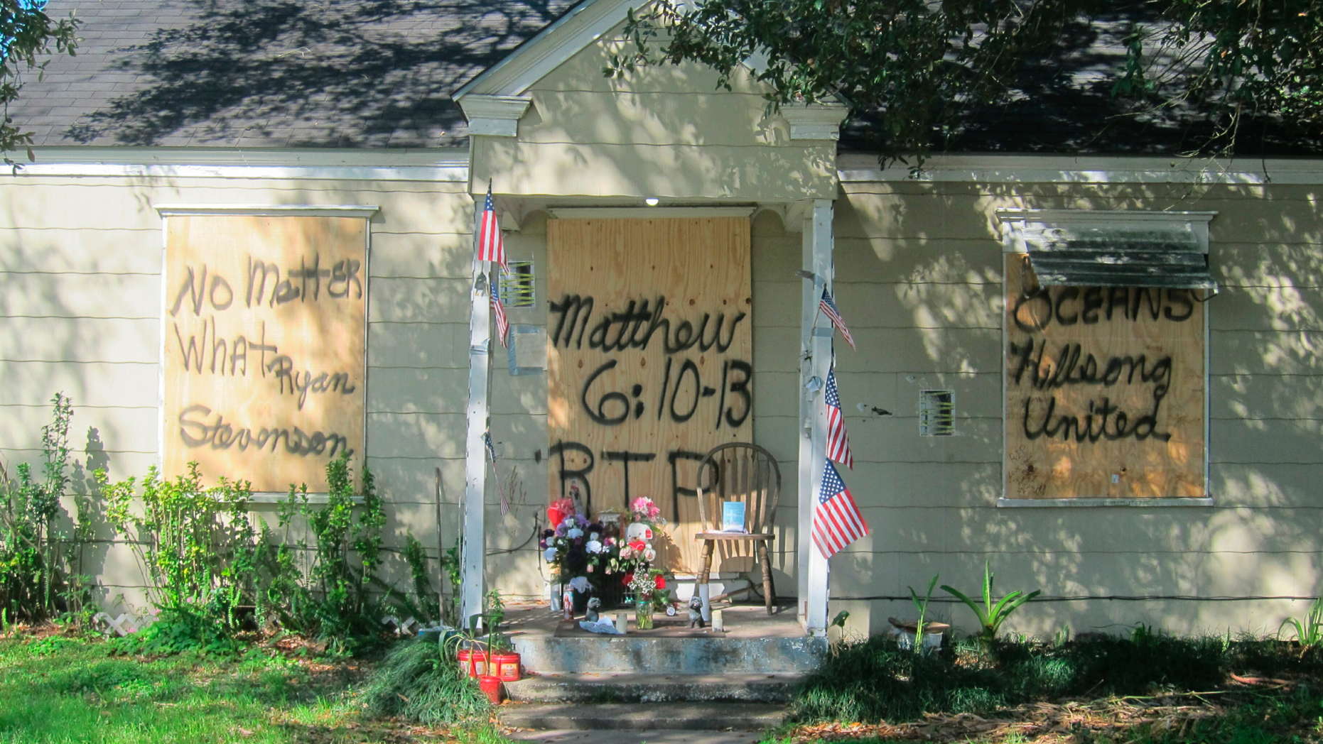 This Feb. 20, 2019 photos shows a makeshift memorial with flowers and candles that has been set up at the front door of a home in Houston where a couple who lived inside were killed during a Jan. 28 drug raid by Houston police. Friends of the Houston couple fatally shot by police during the drug raid of their home continue pushing back against claims the two were criminals. The FBI is investigating, and the officer who requested the search warrant was suspended. (AP Photo/Juan Lozano)