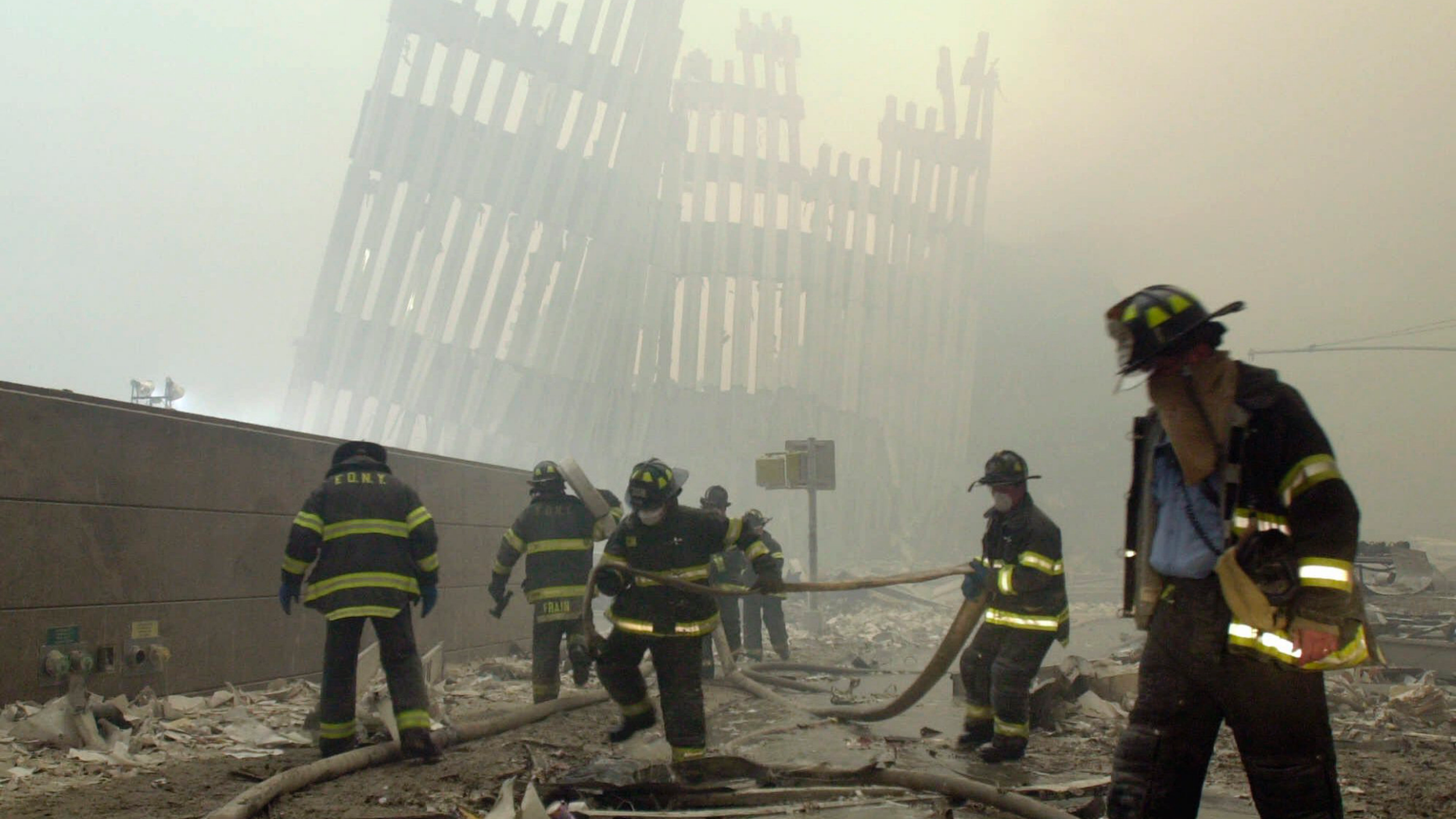 FILE - In this Sept. 11, 2001 file photo, with the skeleton of the World Trade Center twin towers in the background, New York City firefighters work amid debris on Cortlandt St. after the terrorist attacks. On Friday, Feb. 15, 2019, Rupa Bhattacharyya, the September 11th Victim Compensation Fund special master, announced that the compensation fund for victims of the Sept. 11, 2001 terror attacks will cut future payments by 50 to 70 percent because the fund is running out of money. (AP Photo/Mark Lennihan, File)