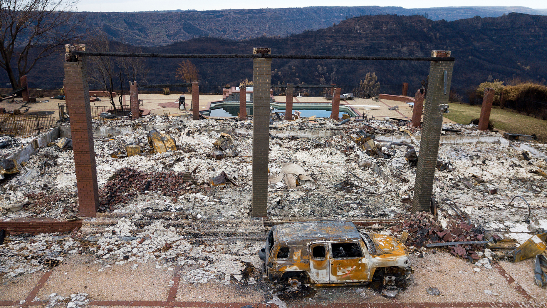 DOSSIER - In this archival photo of December 3, 2018, a vehicle sits in front of a house leveled by Camp Fire in Paradise, California, Pacific Gas & amp; Electric says its equipment could have lit the 2018 campfire, which killed 86 people and destroyed an entire city in northern California. The troubled utility reported Thursday, February 28, 2019, that it had a charge of $ 10.5 billion for firefighting claims in its fourth quarter results. (AP Photo / Noah Berger, File)
