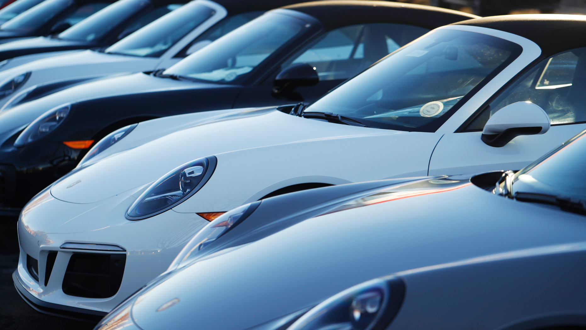 In this Sunday, Feb. 3, 2019, photograph, a long row of unsold 2019 911 Carrera GTS cabriolets sits at a Porsche dealership in Littleton, Colo. Borrowers are behind in their auto loan payments in numbers not seen since delinquencies peaked at the end of 2010, according to the Federal Reserve Bank of New York. (AP Photo/David Zalubowski)