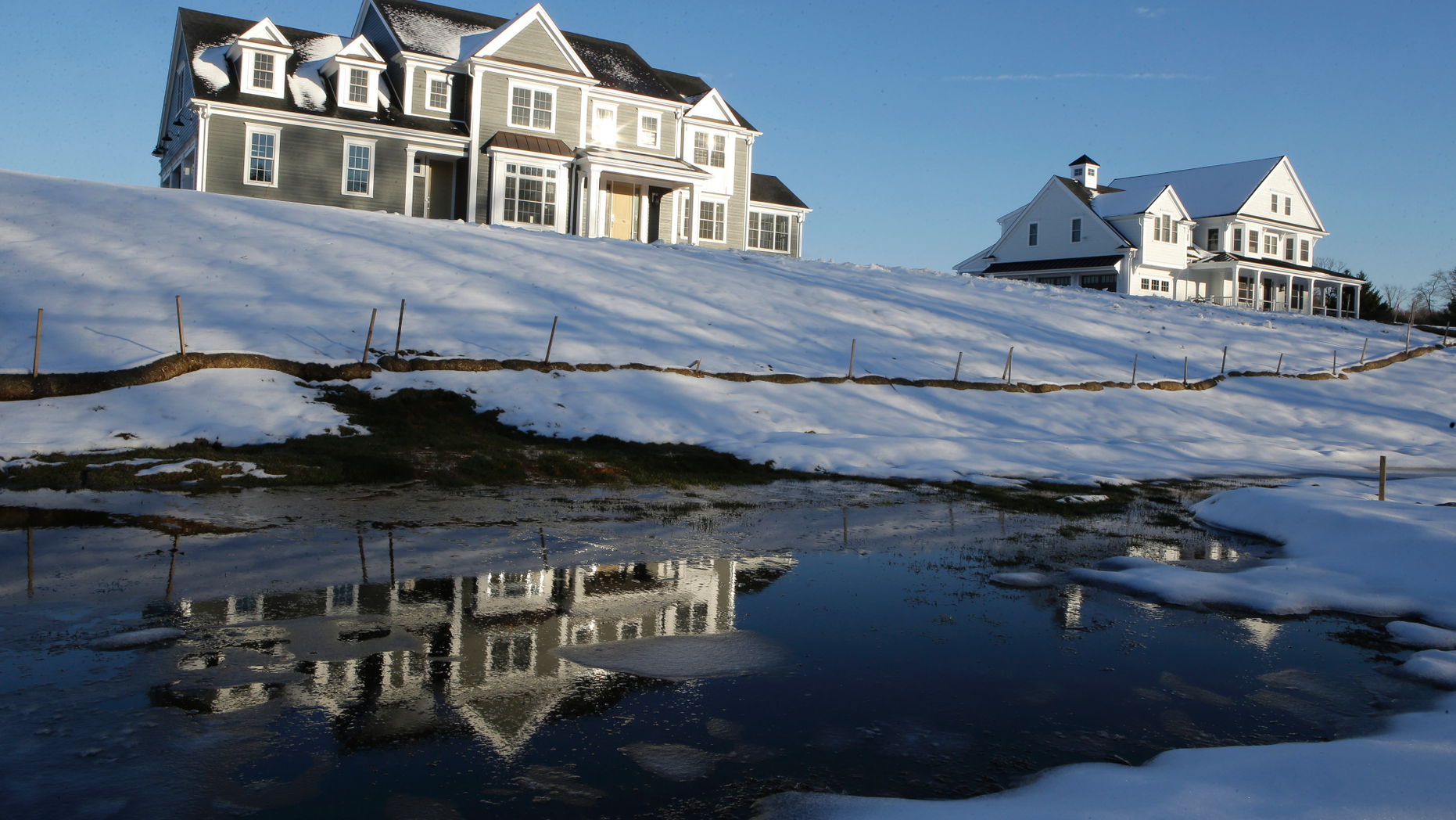 In this Thursday, February 21, 2019, a photo of a newly built house, located in Natick, Massachusetts, is reflected in the water. On Tuesday, February 26, the Commerce Department reported on the construction of homes in the United States in December. (AP Photo / Steven Senne)