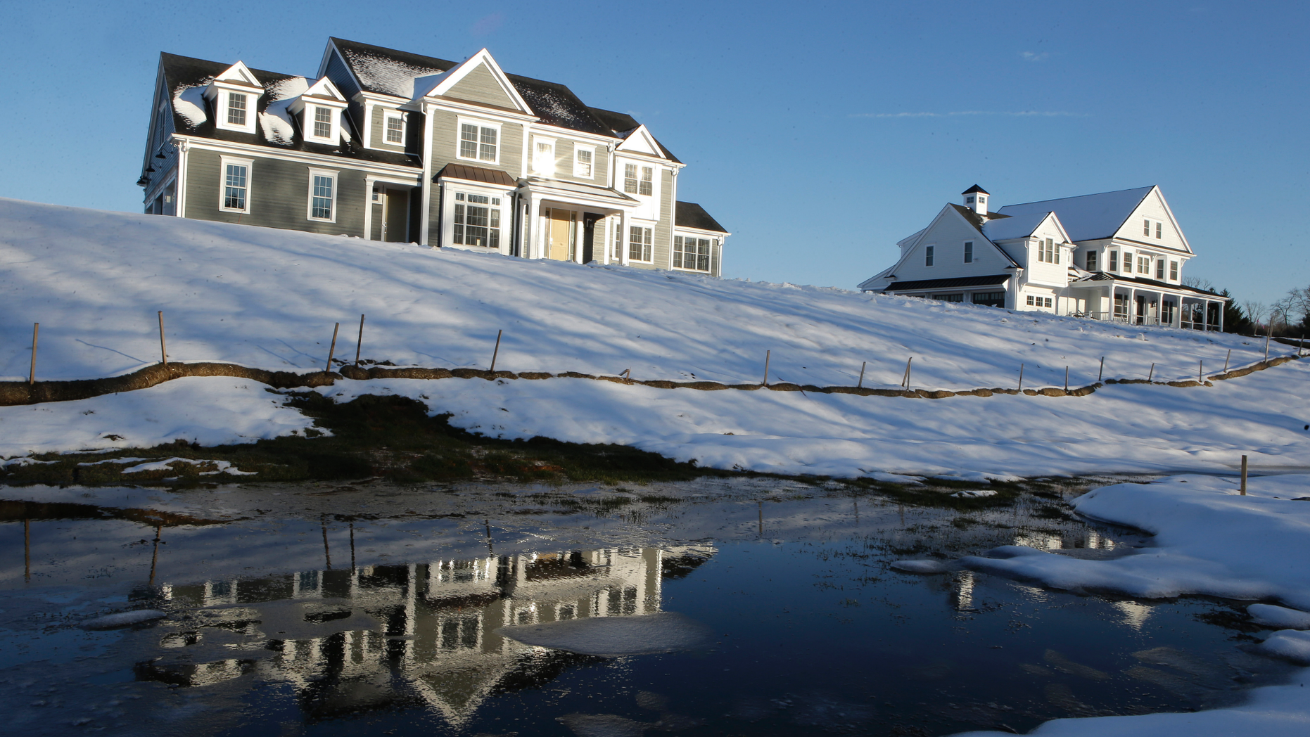 In this Thursday, February 21, 2019, a photo of a newly built house, located in Natick, Massachusetts, is reflected in the water. On Tuesday, February 26, the Commerce Department reported on the construction of homes in the United States in December. (AP Photo / Steven Senne)