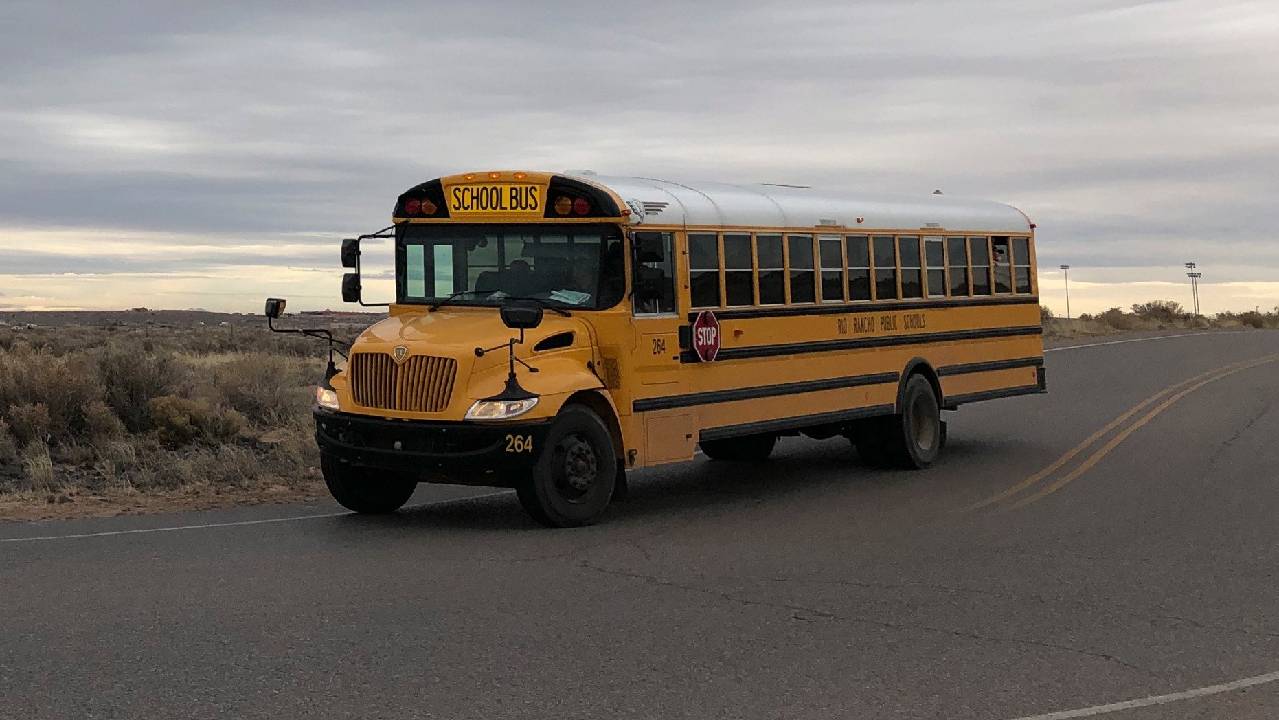 A school bus evacuates students from Sue V. Cleveland High School in Rio Rancho, New Mexico, on Thursday, Feb. 14, 2019, after a shot was fired on the campus. Police and school officials said no one was injured and a suspect was taken into custody. (AP/Russell Contreras)