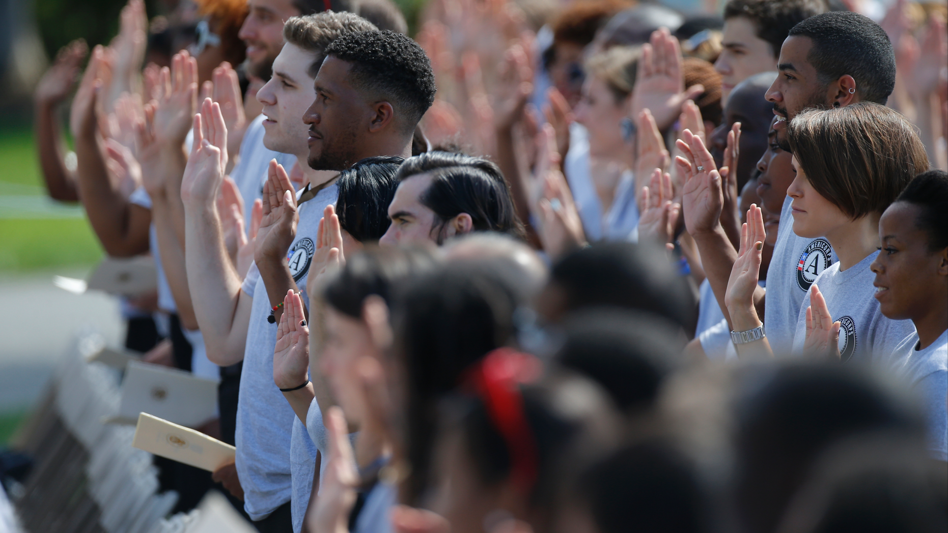 FILE - In this Sept. 12, 2014 file photo, AmeriCorps volunteers take a pledge as President Barack Obama and former President Bill Clinton mark the 20th anniversary of AmeriCorps, which promotes volunteerism and community service, on the South Lawn at the White House in Washington. Hundreds of Teach for America alumni are slamming the educator placement program for telling members to cross the picket line during a potential teacher strike in Oakland, California, or risk losing thousands of dollars at the end of their service. In partnership with the AmeriCorps, Teach for America members can apply for an education award at the end of their service to help pay off student loans. An AmeriCorps spokeswoman couldn't immediately provide comment but said striking is prohibited. (AP Photo/Charles Dharapak, File)