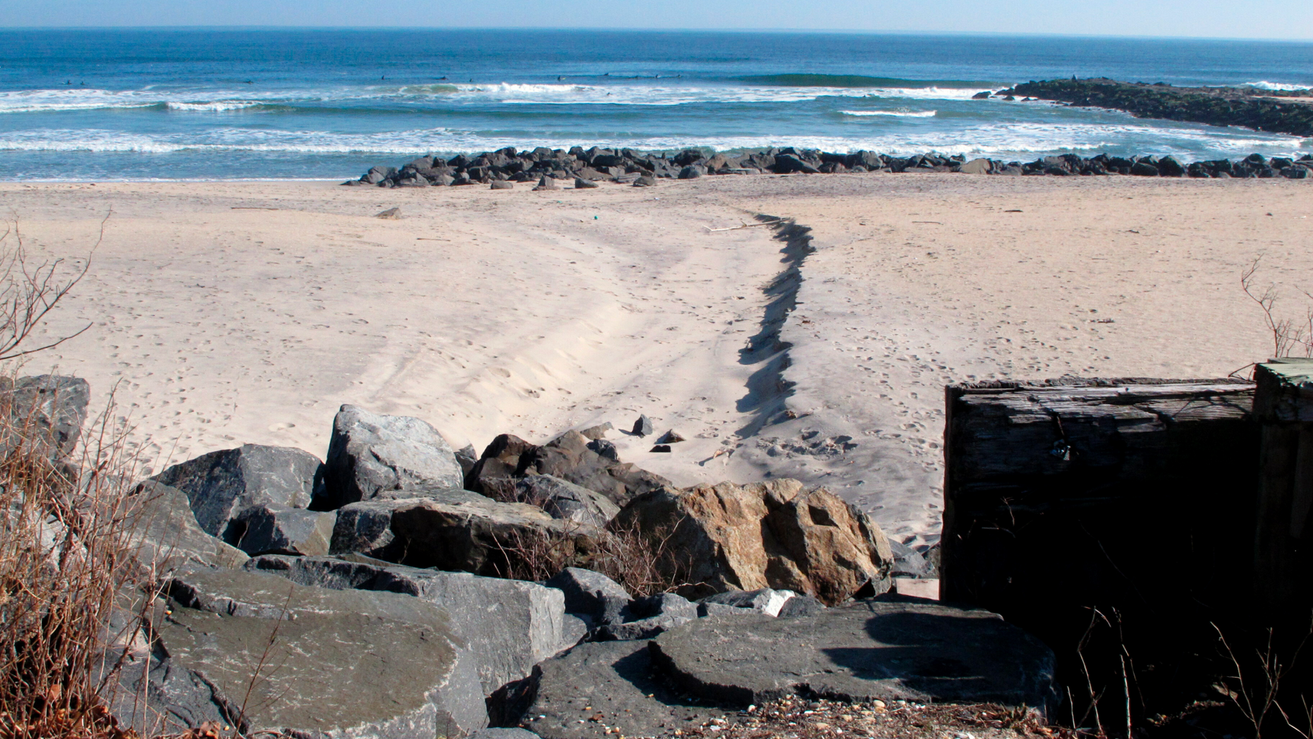 This Feb. 5, 2019 photo shows boulders leading down to the beach in Deal, N.J. on a street end that the town plans to give up to a private property owner. Beach access advocates fear a popular spot for surfers, fishermen and others to get onto the sand will be blocked off, but the town insists that won't be the case. (AP Photo/Wayne Parry)