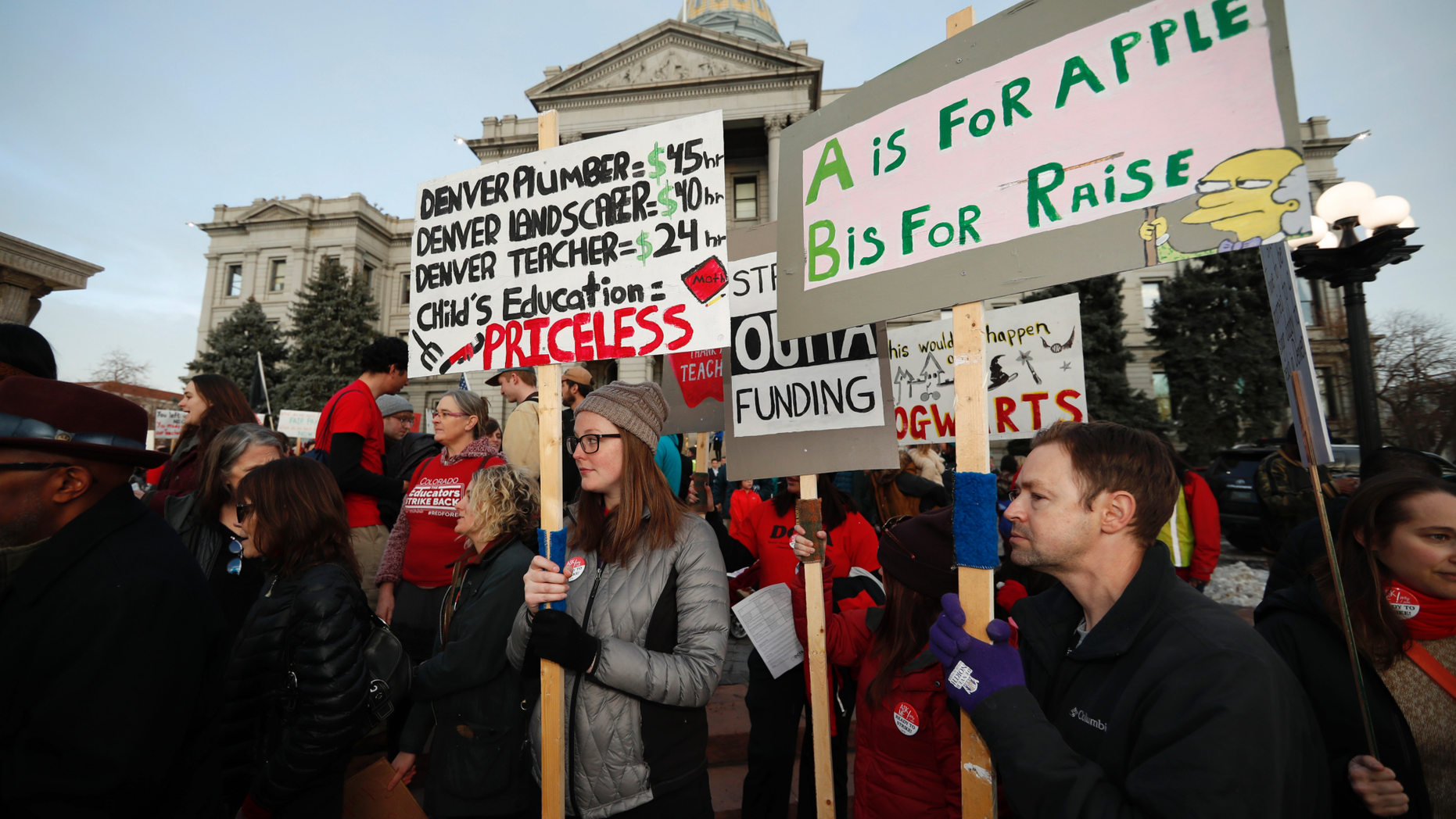 FILE - In this Wednesday, Jan. 30, 2019, file photo, teachers from the Denver Public Schools carry placards as they wait to march after a rally in support of a strike outside the State Capitol in Denver. Denver teachers are planning to strike Monday, Feb. 11, 2019 after failed negotiations with the school district over base pay. (AP Photo/David Zalubowski, File)