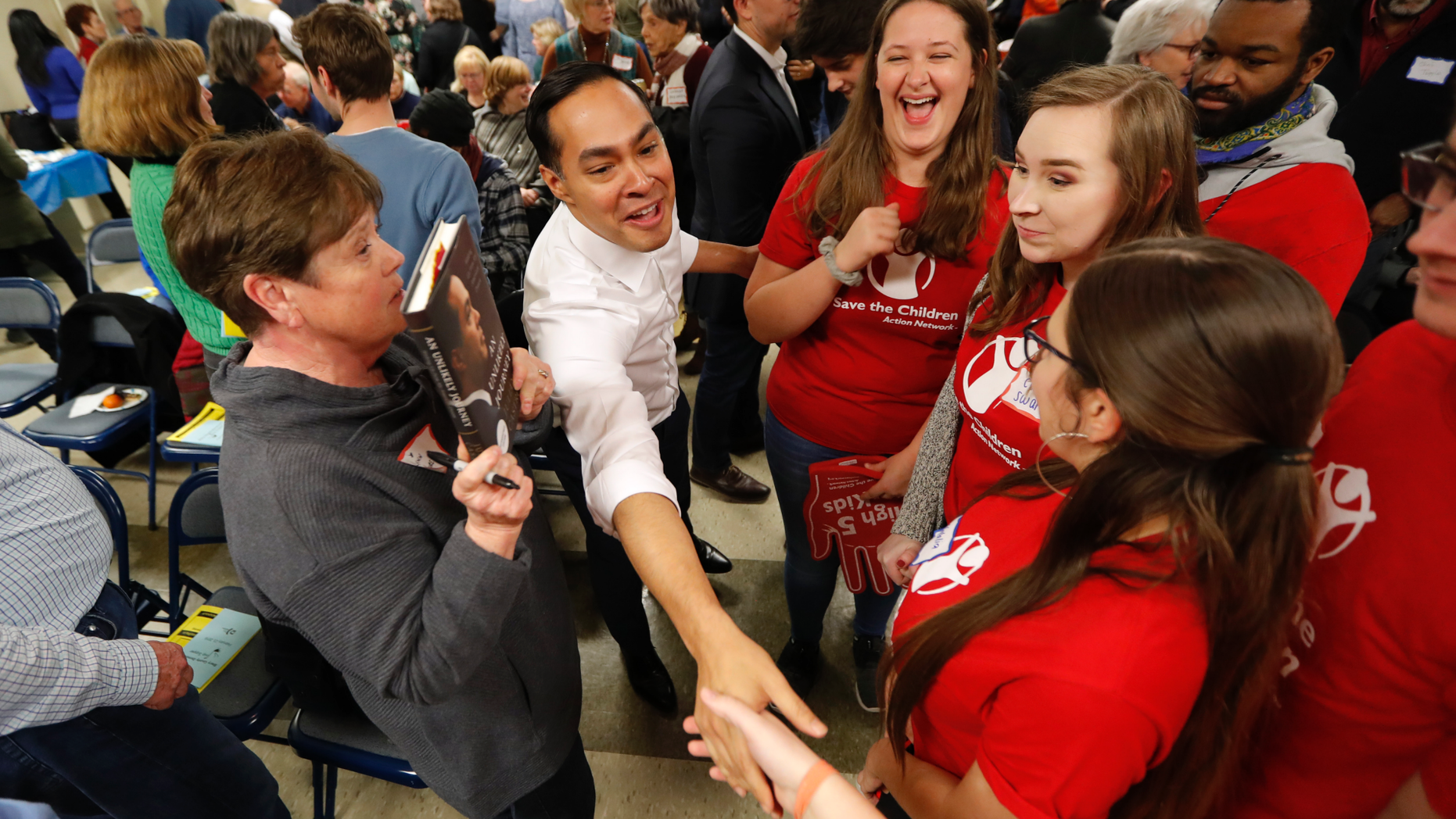 Former Housing and Urban Development Secretary and 2020 Democratic presidential hopeful Julian Castro, center, greets Iowa State students at the Story County Democrats' annual soup supper fundraiser, Saturday, Feb. 23, 2019, in Ames, Iowa. (AP Photo/Charlie Neibergall)