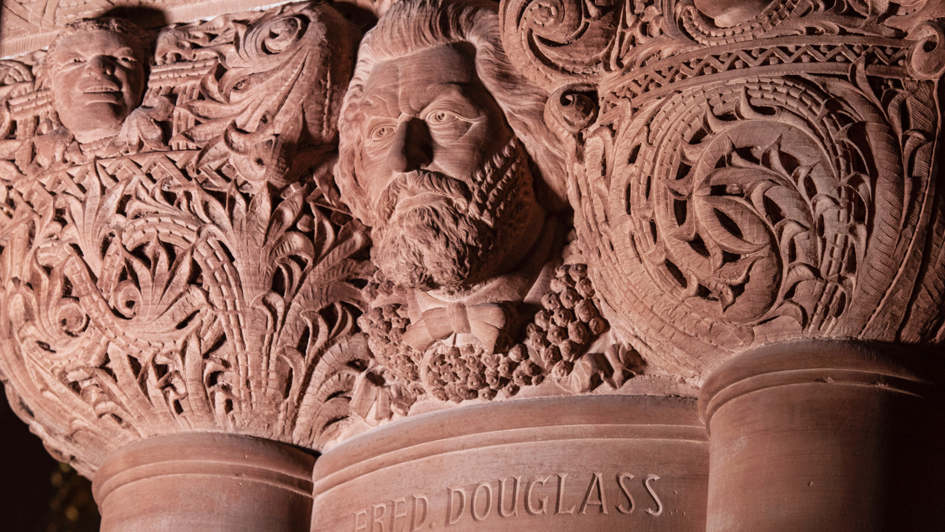 This photo Wednesday, Feb. 27, 2019, provided by the New York Governor's Office shows the carved face and name of abolitionist Frederick Douglass in the New York state Capitol, in Albany, N.Y. The Douglass face and name, believed to have been carved into a third-floor column into the ornate interior stonework of the "Million Dollar Staircase" from 1884 to 1898, was corrected on Wednesday to add the second "s" to his last name. (New York Governor's Office via AP)