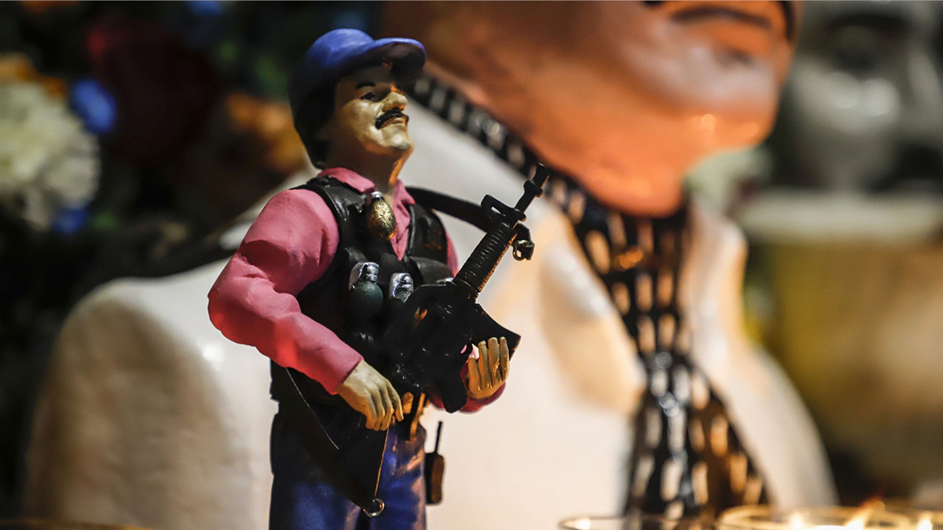 A statue of Mexican drug lord Joaquin "El Chapo" Guzman, is displayed for sale near a bust of narco-saint Jesus Malverde, at his chapel in Culiacan, Sinaloa state in northwest Mexico on Feb. 19. (Photo by RASHIDE FRIAS / AFP) (Photo credit should read RASHIDE FRIAS/AFP/Getty Images)