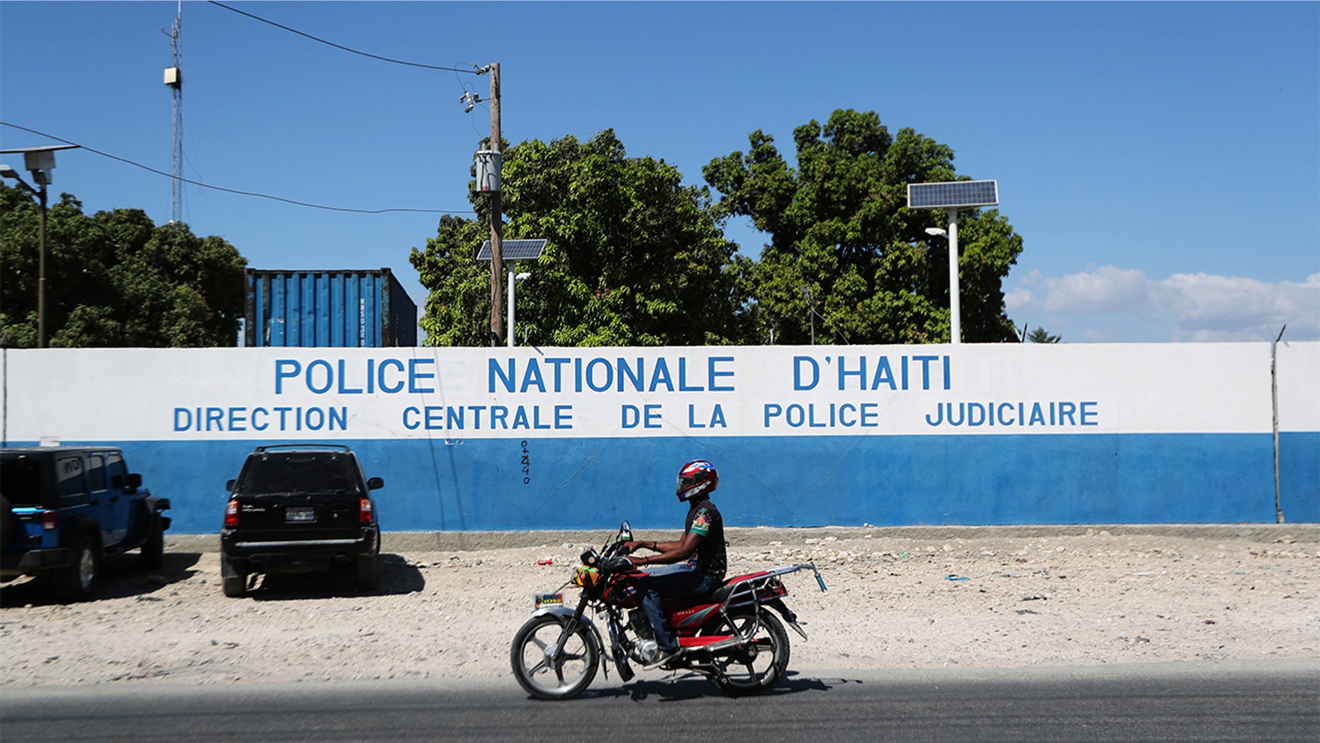 A man rides a bike in front of a main Haitian police station, where according to local media, a group of foreign nationals including Americans were detained, after anti-government protests, in Port-au-Prince, Haiti. (Ivan Alvarado / REUTERS)