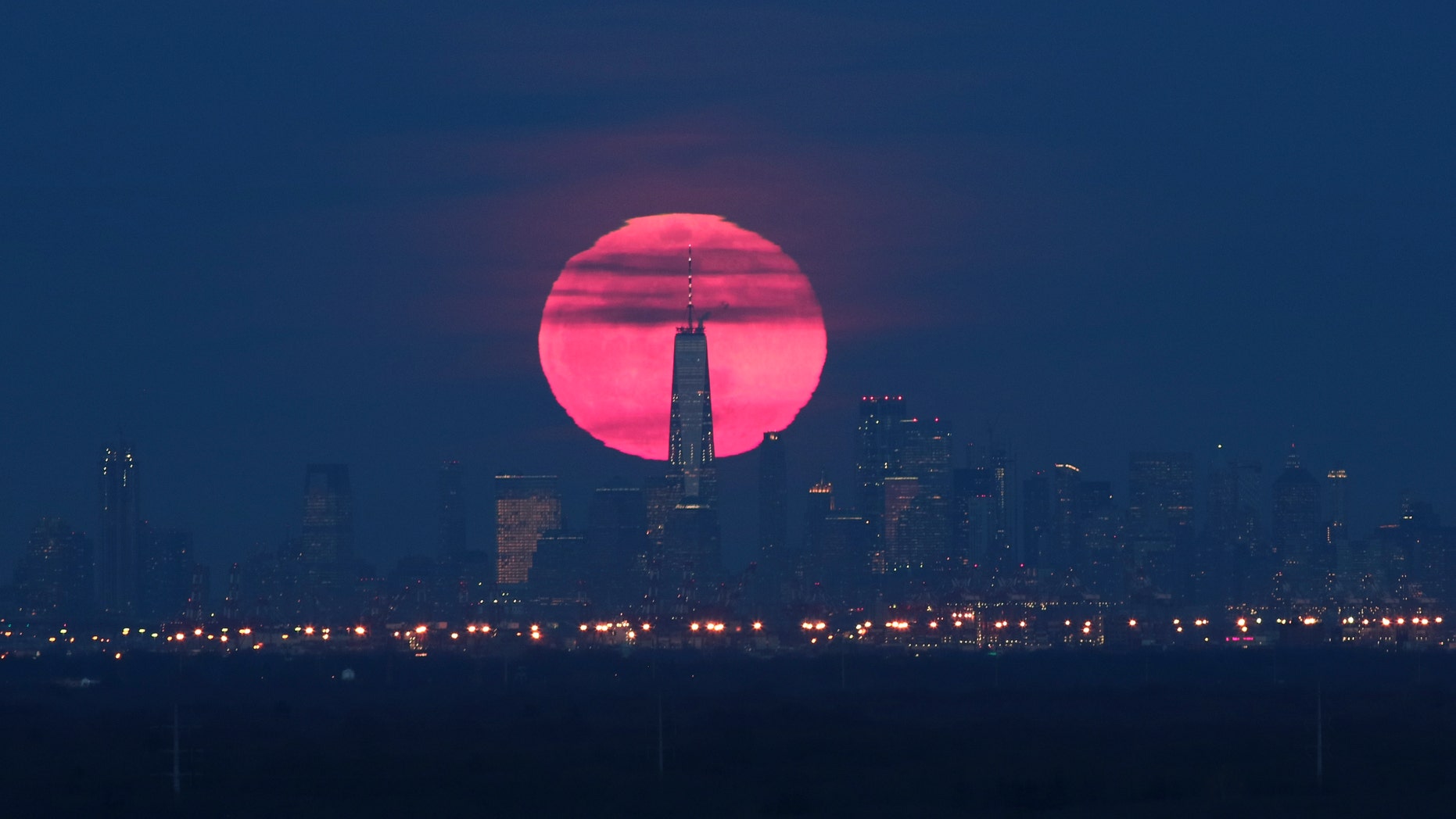 The super snow moon rises behind lower Manhattan and One World Trade Center in New York City on February 19, 2018 as seen from Green Brook Township, New Jersey.