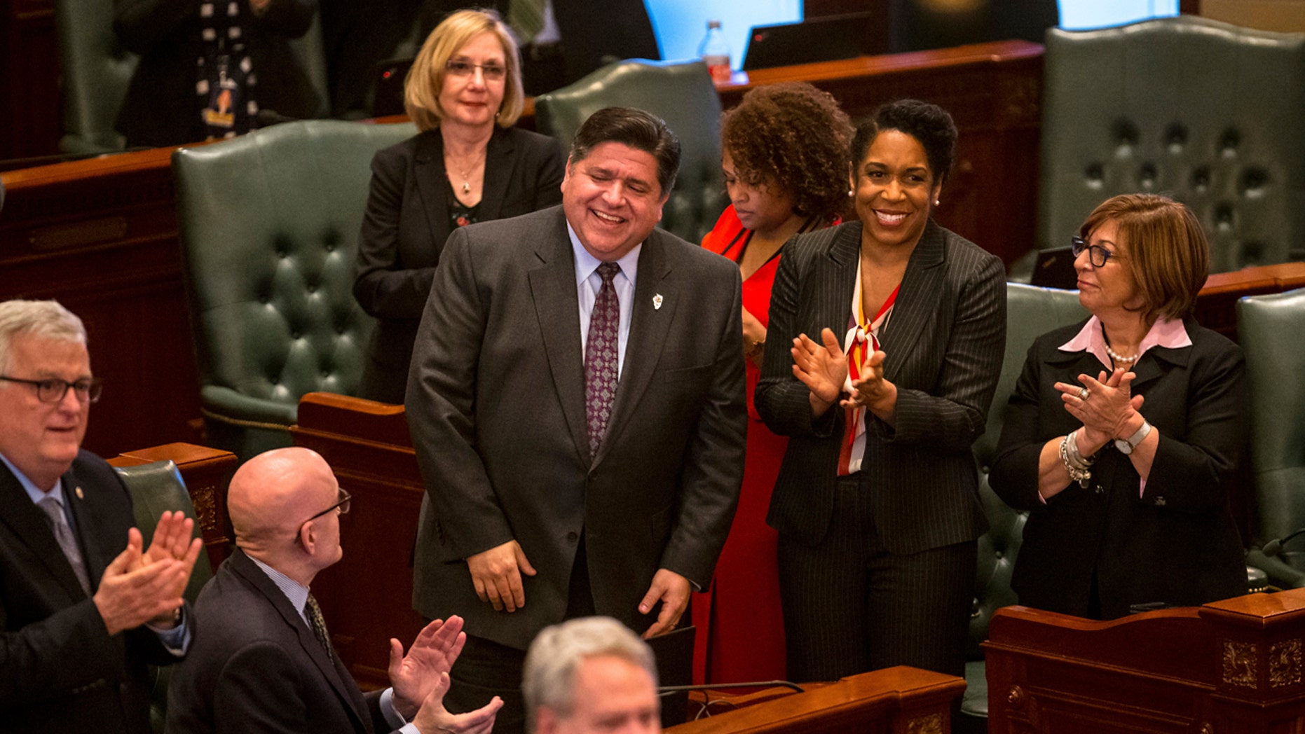 The governor of Illinois, JB Pritzker, left, and Illinois lieutenant-governor, Juliana Stratton, right, are recognized in the Capitol House of Illinois on Thursday 14 February 2019, in Springfield, Illinois. Illinois lawmakers reacted quickly. One of Pritzker's best campaign promises, a gradual increase in the statewide minimum wage from $ 8.25 to $ 15 an hour, is more than double the base salary required by most of its Midwestern neighbors. (Justin L. Fowler / The State Journal-Register via AP)