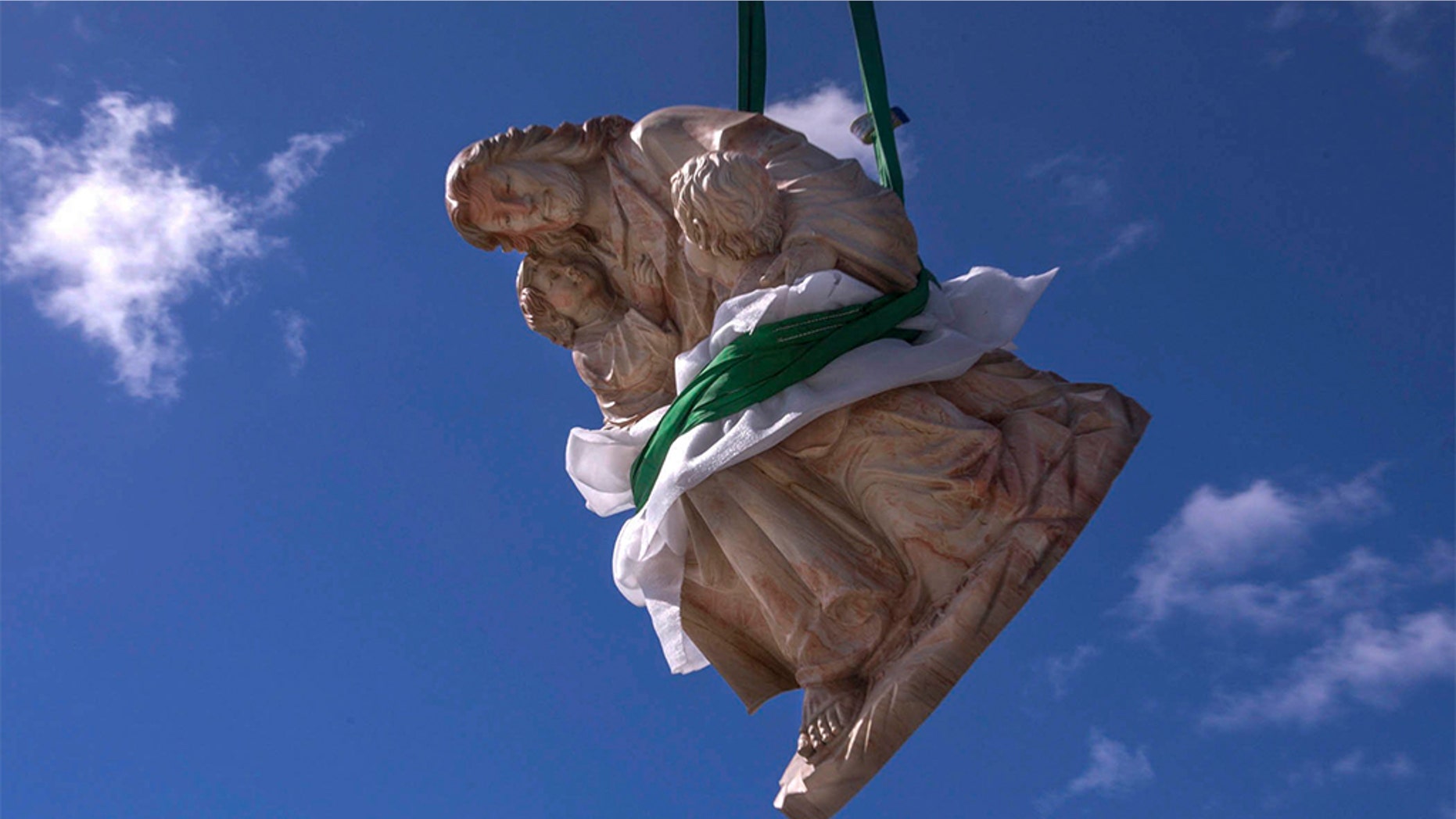 February 7, 2019 - Palm Beach, Florida, U.S. - A crane hoists a heavy limestone sculpture of Jesus with two children high above the roof of St. Edward Roman Catholic Church, to its base in the church hall courtyard. (Damon Higgins/Palm Beach Daily News via ZUMA Wire)