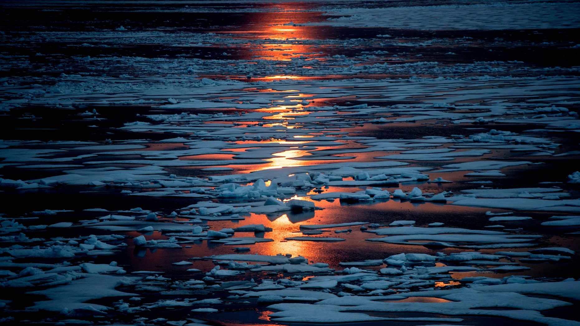 FILE- In this July 23, 2017, file photo the midnight sun shines across sea ice along the Northwest Passage in the Canadian Arctic Archipelago.