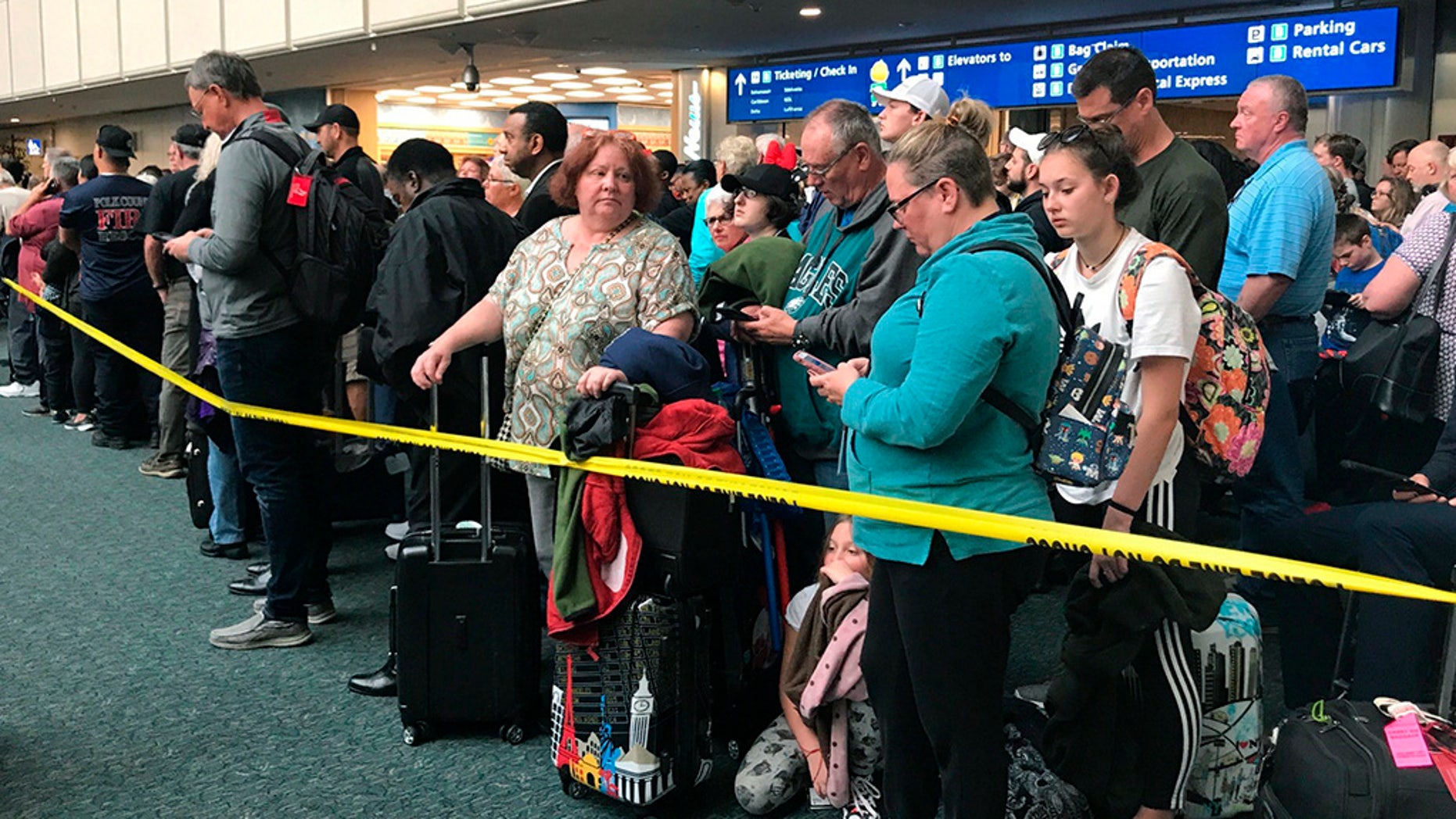   People are waiting to pass the security at Orlando International Airport after a seemingly temporary suicide suicide flight. (Jonathan Hayward / Canadian Press via AP) 