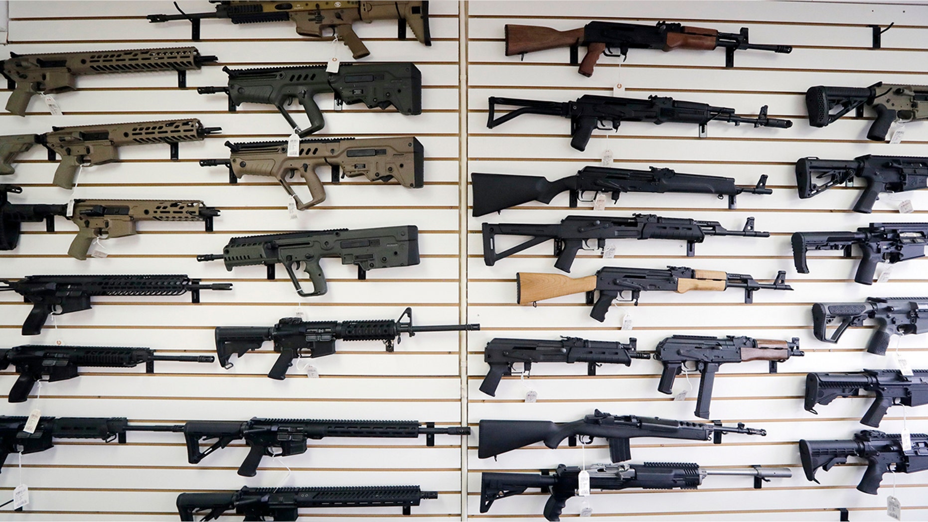 In this photo taken Oct. 2, 2018, semi-automatic rifles fill a wall at a gun shop in Lynnwood, Wash. (AP Photo/Elaine Thompson, File)