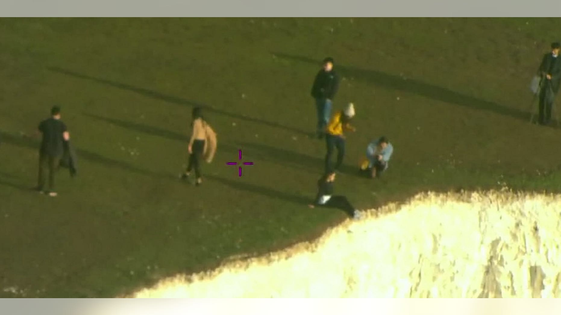 Tourists were caught on camera dangling their feet over the cliff's edge.