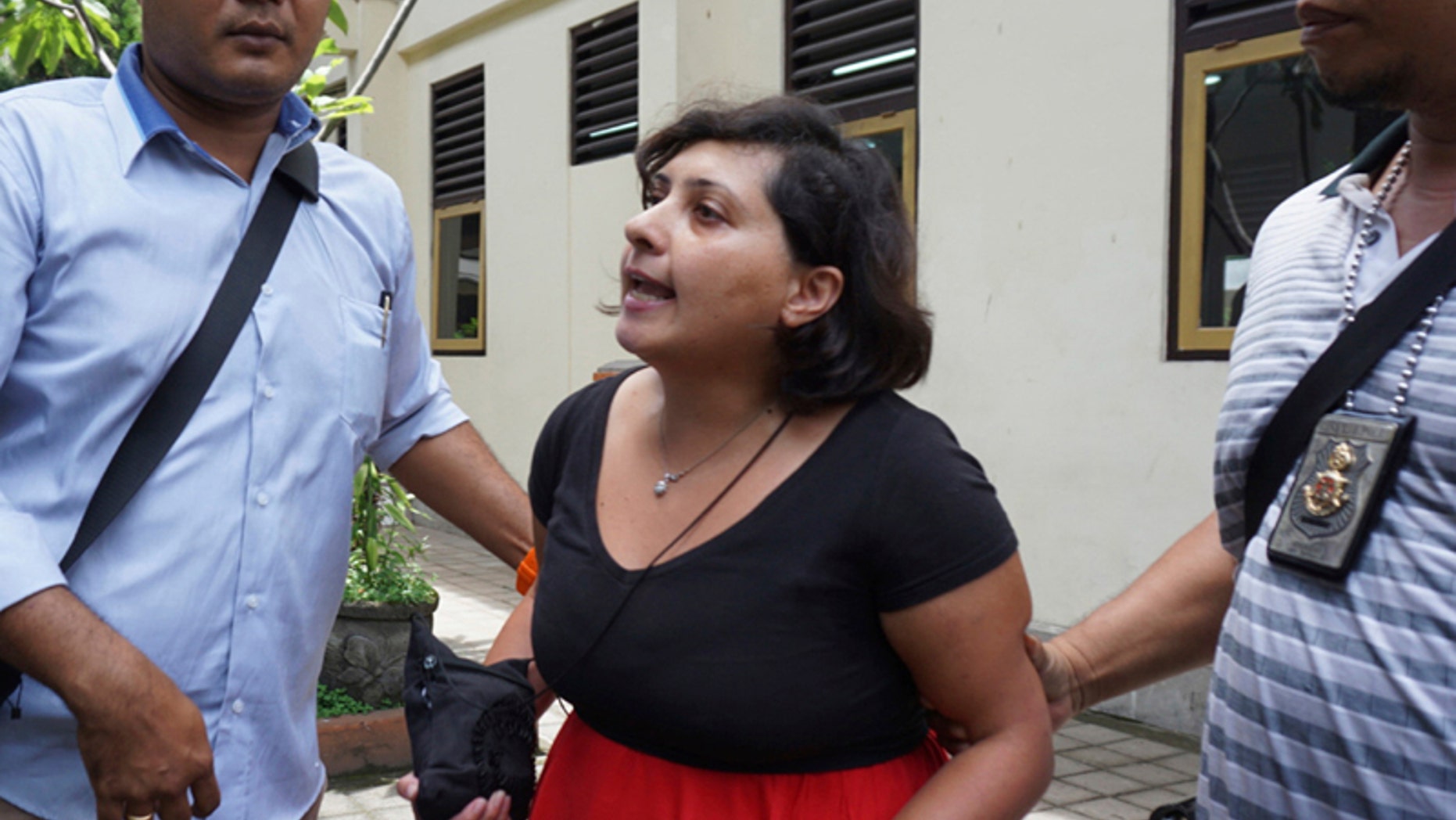 Auj-e Taqaddas is escorted by investigators after her trial in Bali, Indonesia, on Wednesday. (AP Photo)