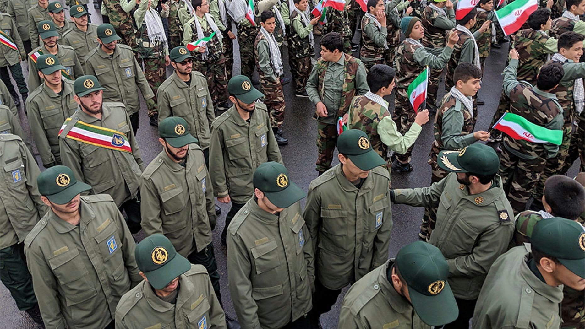 School students wave their national flags as Revolutionary Guard members arrive in Azadi, freedom square, during a ceremony celebrating the 40th anniversary of Islamic Revolution, in Tehran, Iran, on Monday.