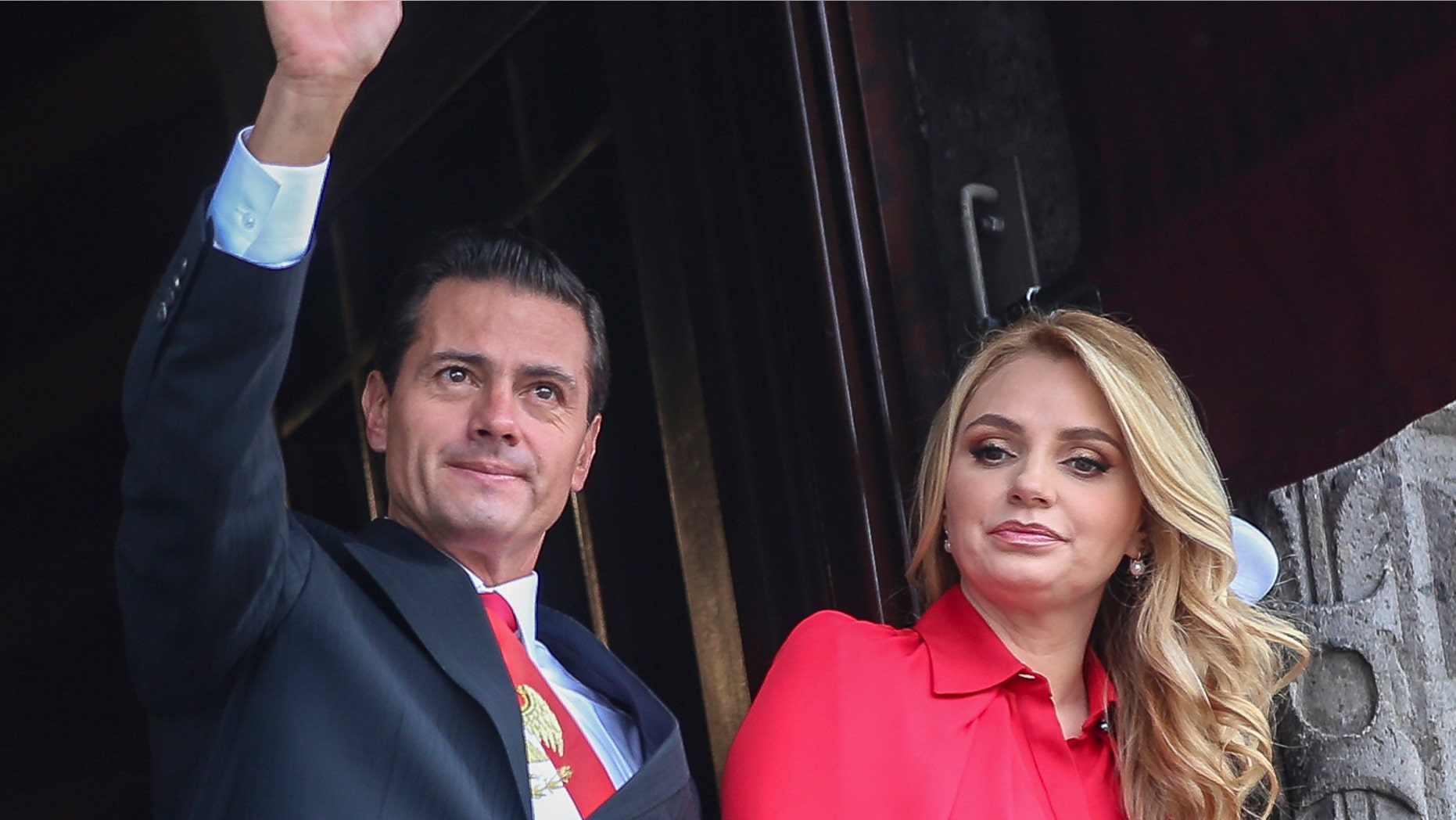 In this Sept. 16, 2018 file photo, Mexico's President Enrique Pena Nieto waves from a National Palace balcony, accompanied by first lady Angelica Rivera, during the Independence Day military parade in the Zocalo of Mexico City. (AP Photo/Anthony Vazquez, File)