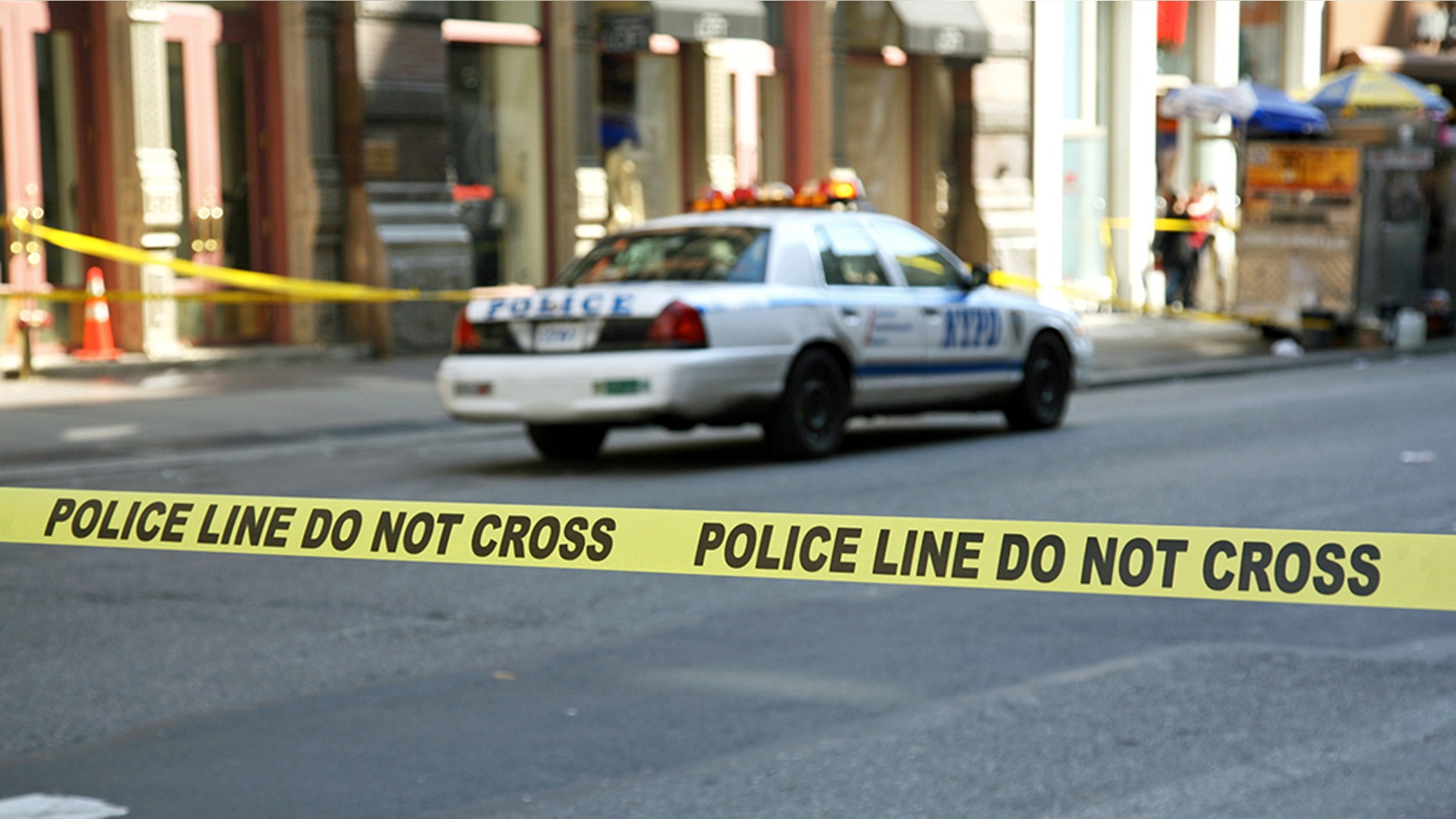 Police tape hangs across a street in front of a building, New York City, New York, USA.