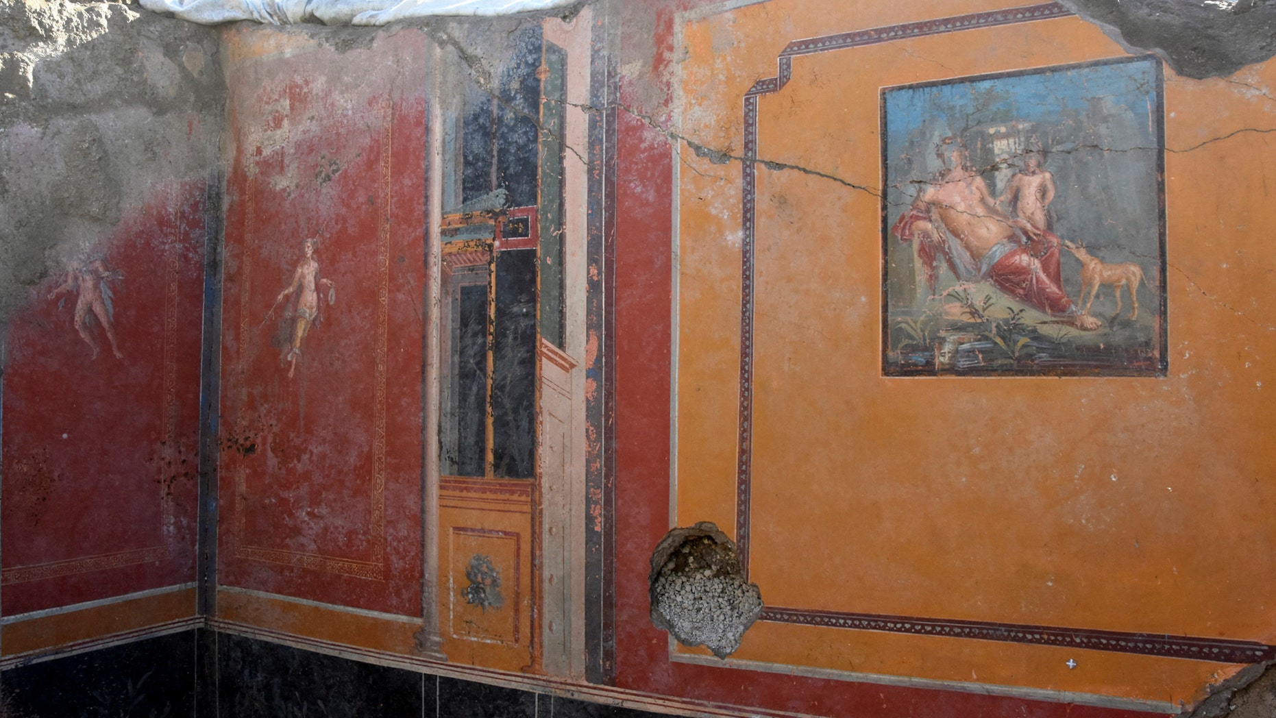 This undated photo provided Thursday, Feb. 14, 2019 by the Parco Archeologico di Pompei (Archeological Park of Pompei) shows the atrium of a house with a fresco portraying the mythological hunter Narcissus, right, in Pompeii, near Naples, Italy. Archaeologists have discovered a fresco in an ancient Pompeii residence that portrays the mythological hunter Narcissus, who fell in love with his own reflection, in a house where a fresco was found late last year depicting a sensual scene between the Roman god Jupiter disguised as a swan and Leda, a queen of Sparta from Greek mythology. (Parco Archeologico di Pompei via AP)