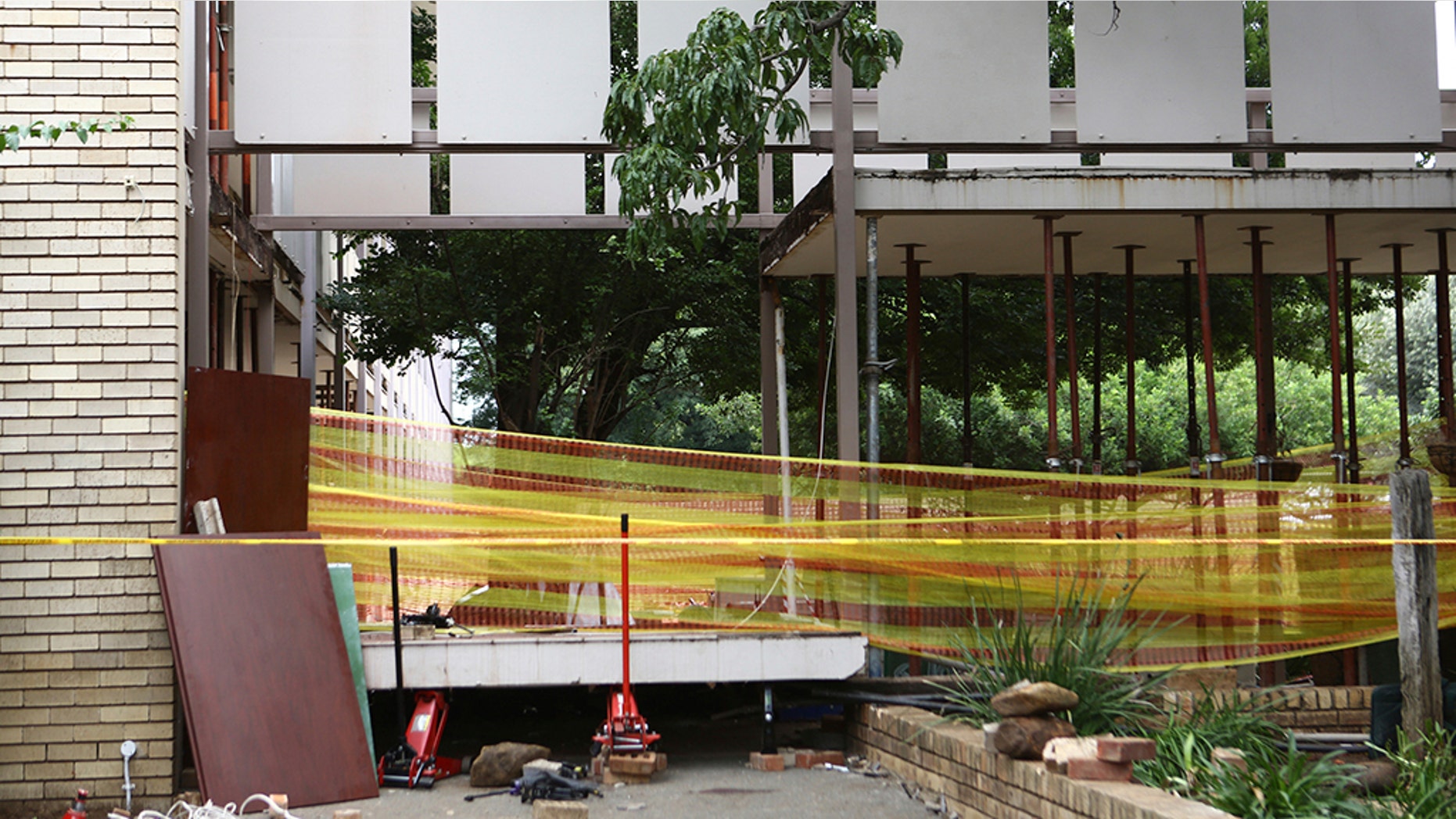 Police tape cordons off the site of a walkway collapse at the Driehoek High School in Vanderbijlpark, South Africa, Friday, Feb. 1, 2019. At least 3 students were killed and scores injured at the school near Johannesburg, a South African official said. (AP Photo)