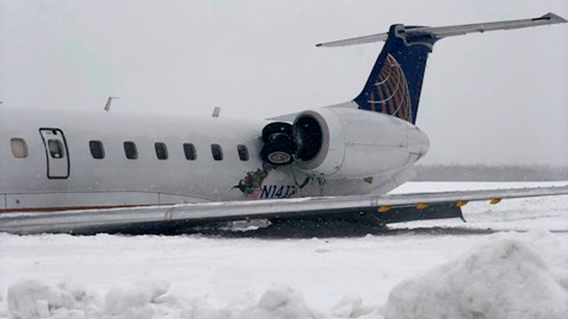 A United Express regional jet that slid off a runway during a snow storm is seen where it came to a rest at Presque Isle International Airport on Monday, March 4.