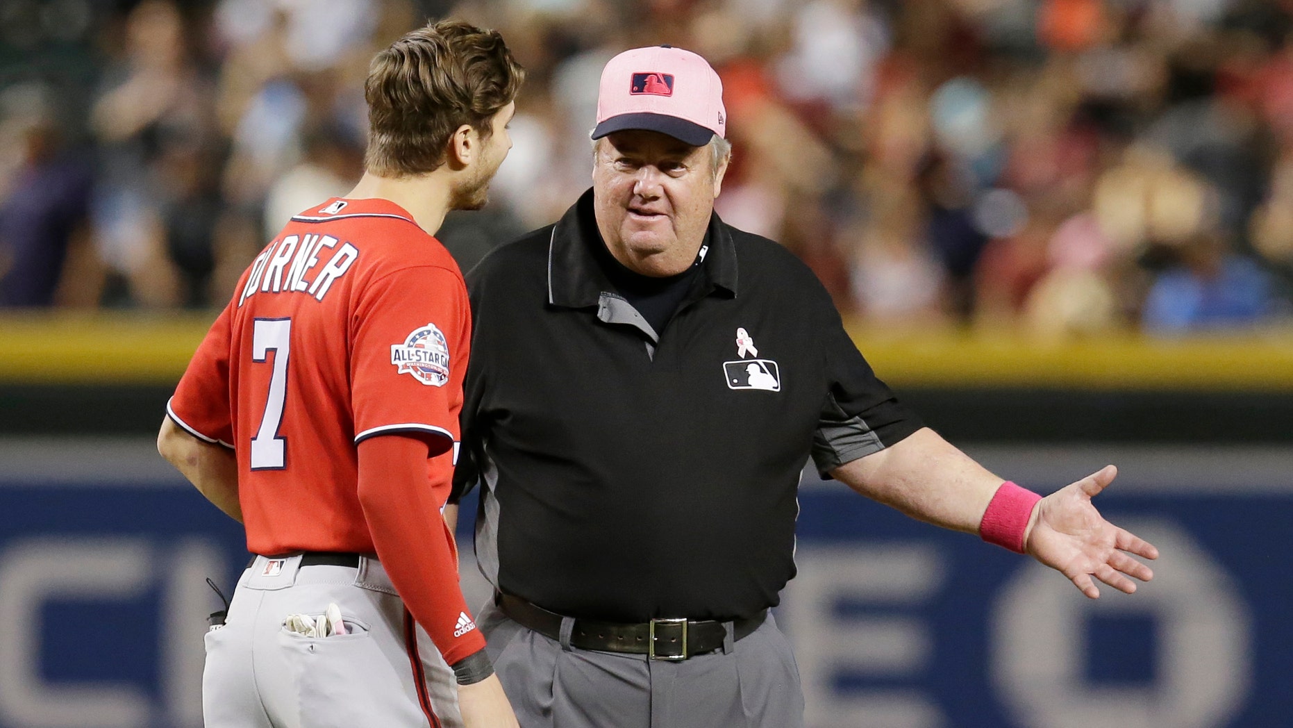 FILE - In this May 13, 2018, file photo, MLB umpire Joe West, right, talks with a player in the ninth inning during a baseball game between the Arizona Diamondbacks and the Washington Nationals in Phoenix. West, who has umpired more than 5,000 big league games, said the 2016 TrackMan computer system test was far from perfect.