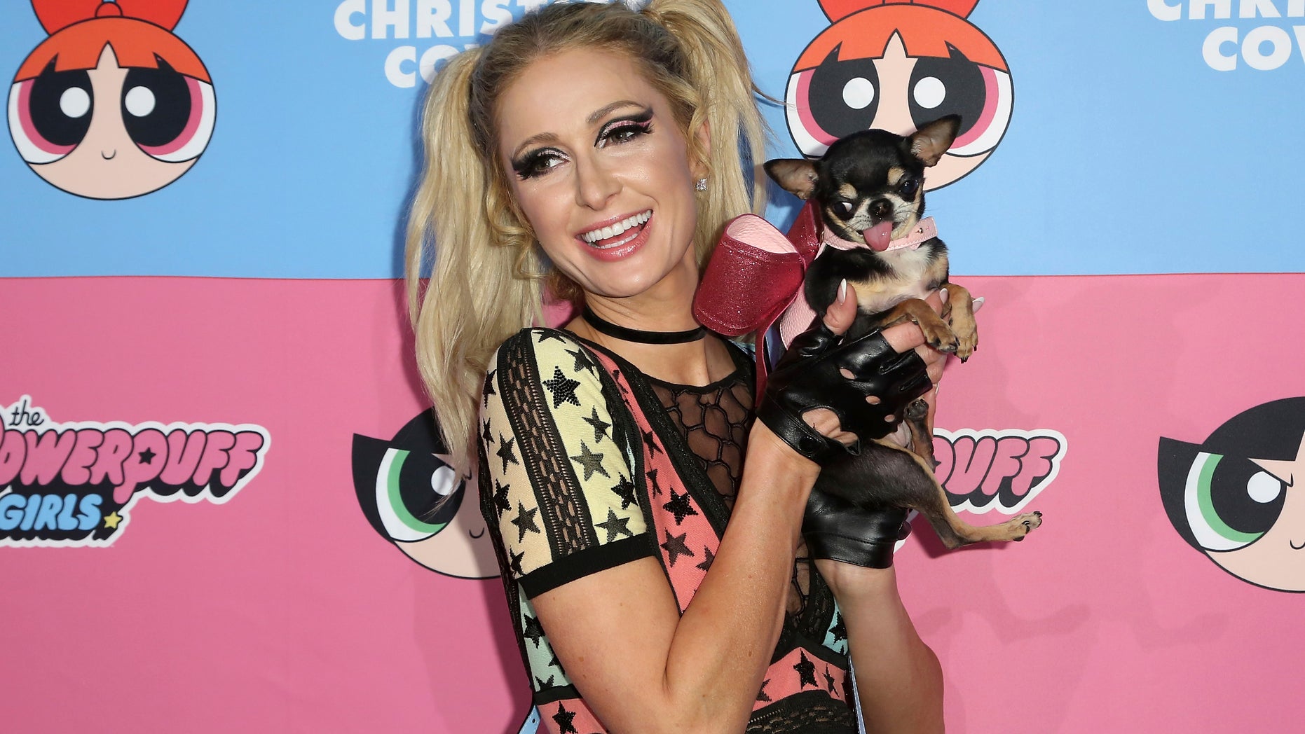 Paris Hilton arrives at the Christian Cowan x The Powerpuff Girls Fashion Show. Later that day, her father posted a cryptic message on her Instagram.
