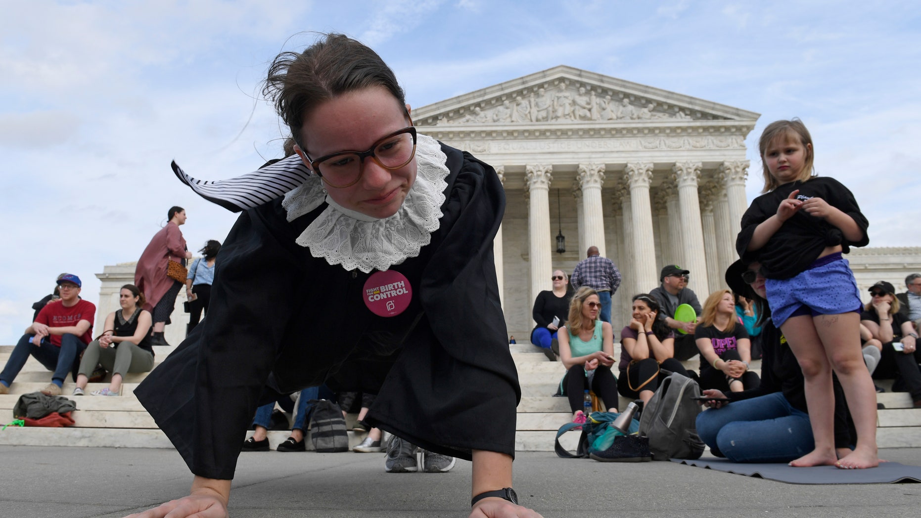 Alice Wisbiski, dressed as Supreme Court Associate Justice Ruth Bader Ginsburg, is joined by others for some exercise on the courthouse steps in Washington on Friday. This, to mark Ginsburg's 86th birthday.
