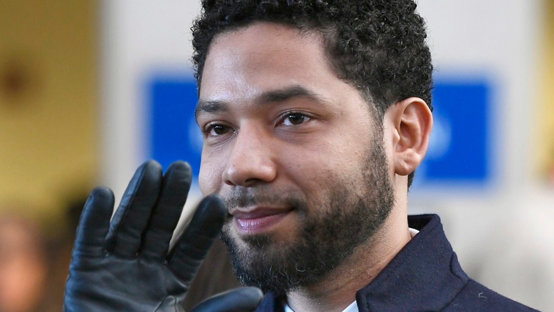 Actor Jussie Smollett smiles and waves to supporters before leaving Cook County (Ill.) Court after his charges were dropped in Chicago. (Associated Press)