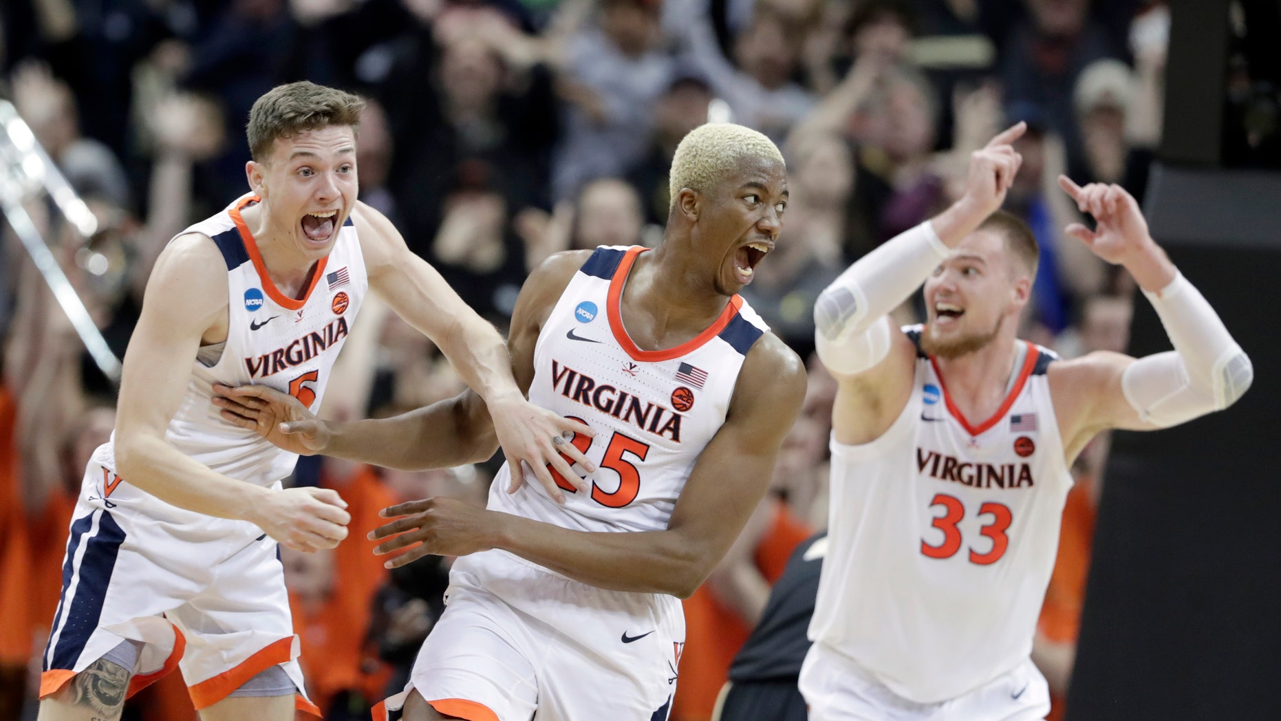 Mamadi Diakite of Virginia, center, reacts with teammates Kyle Guy and 33-year-old Jack Salt after firing a shot at overtime in the South Regional final of the NCAA tournament against Purdue, Saturday, March 30, 2019, in Louisville. , Ky. (Associated Press)