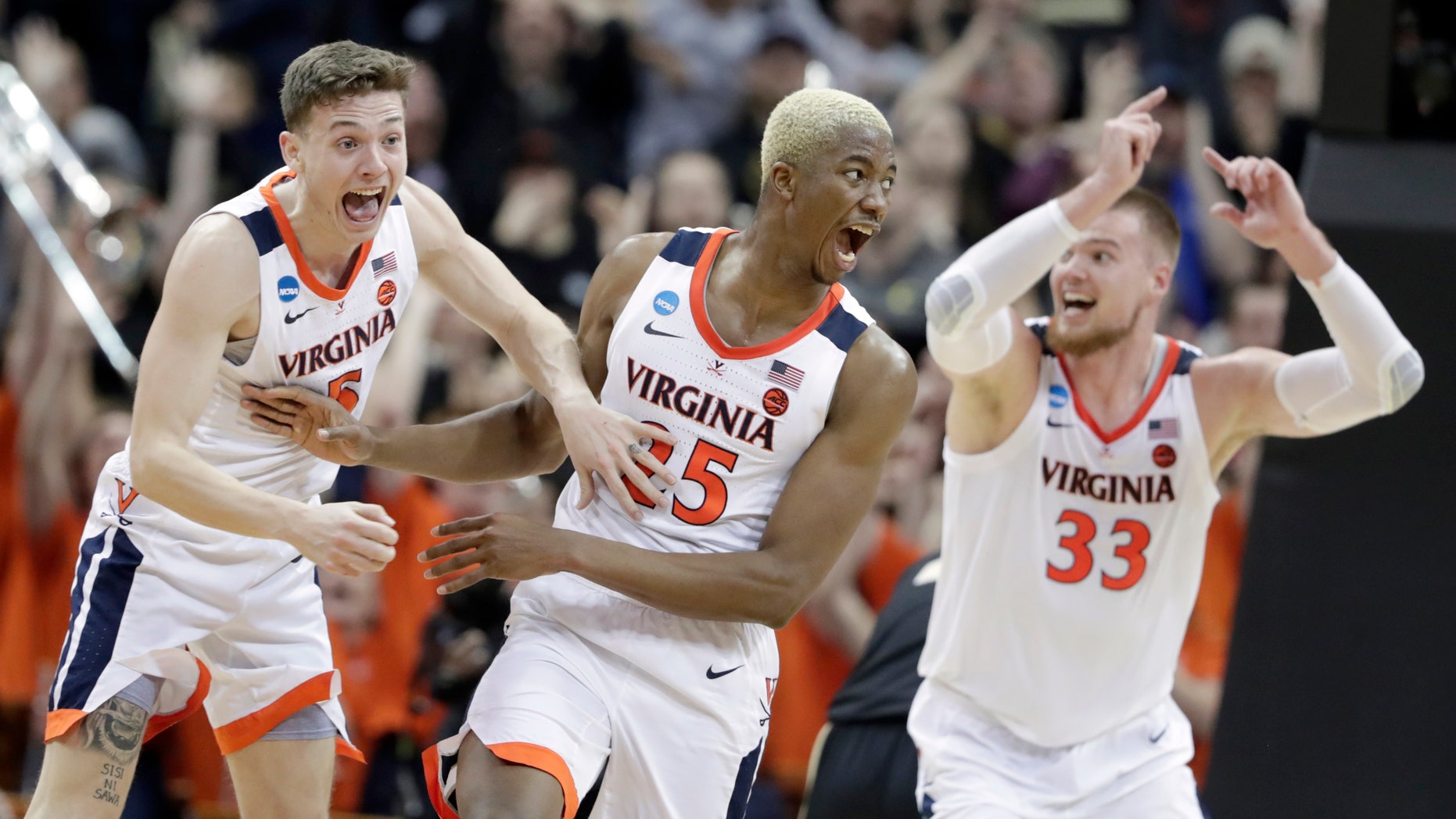 Virginia's Mamadi Diakite, center, reacts with teammates Kyle Guy and Jack Salt (33) after hitting a shot to send the game into overtime in the men's NCAA Tournament college basketball South Regional final game against Purdue, Saturday, March 30, 2019, in Louisville, Ky. (Associated Press)