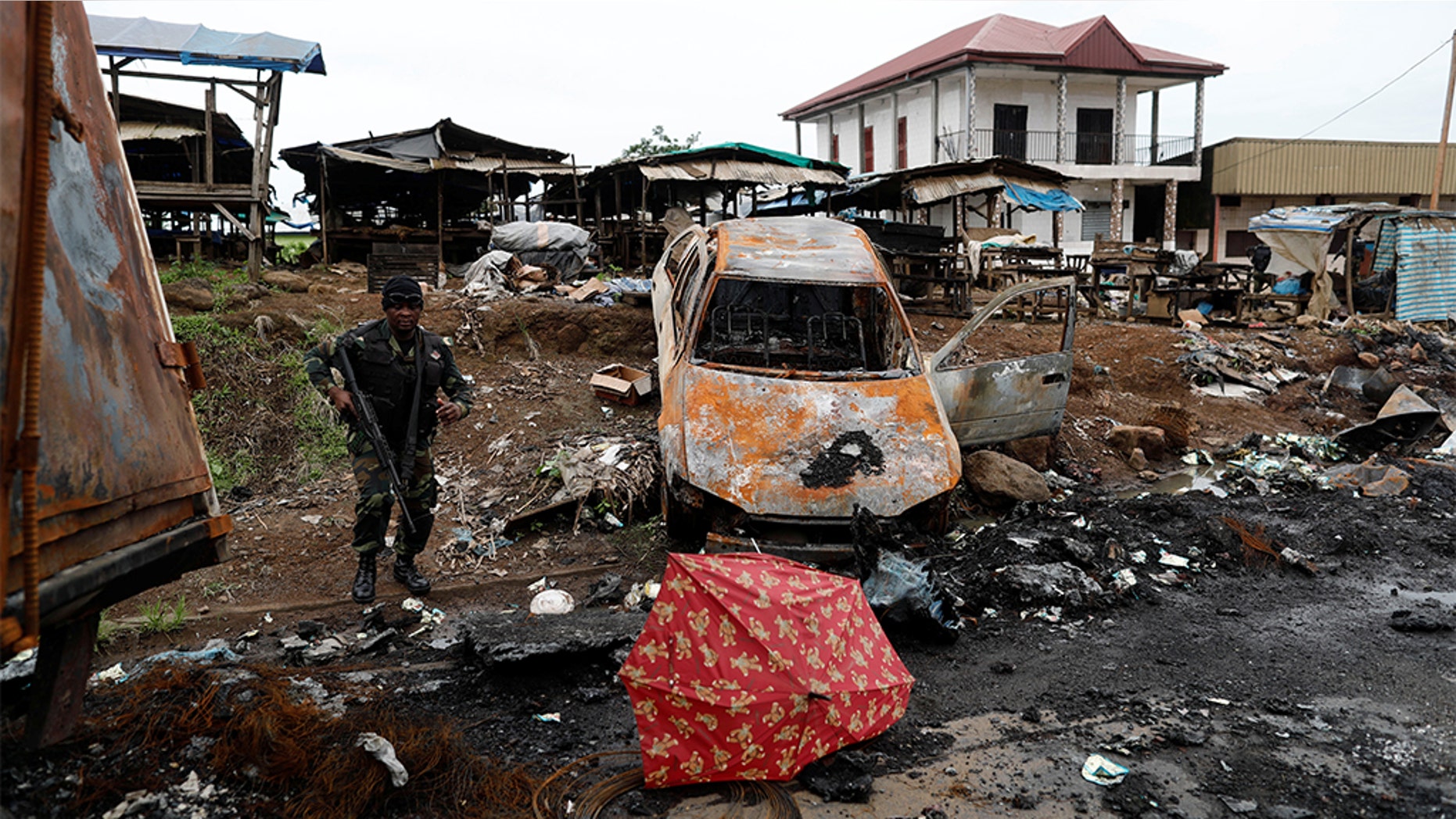 A Cameroonian elite Rapid Intervention Battalion (BIR) member walks past a burnt car while patrolling in the city of Buea in the anglophone southwest region, Cameroon October 4, 2018. Picture taken October 4, 2018.